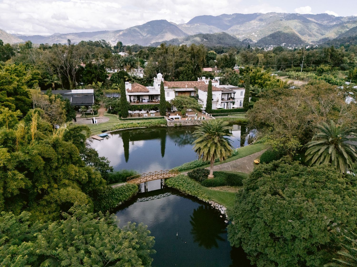 Scenic mountain landscape with lush gardens and waterways at a luxury estate property.