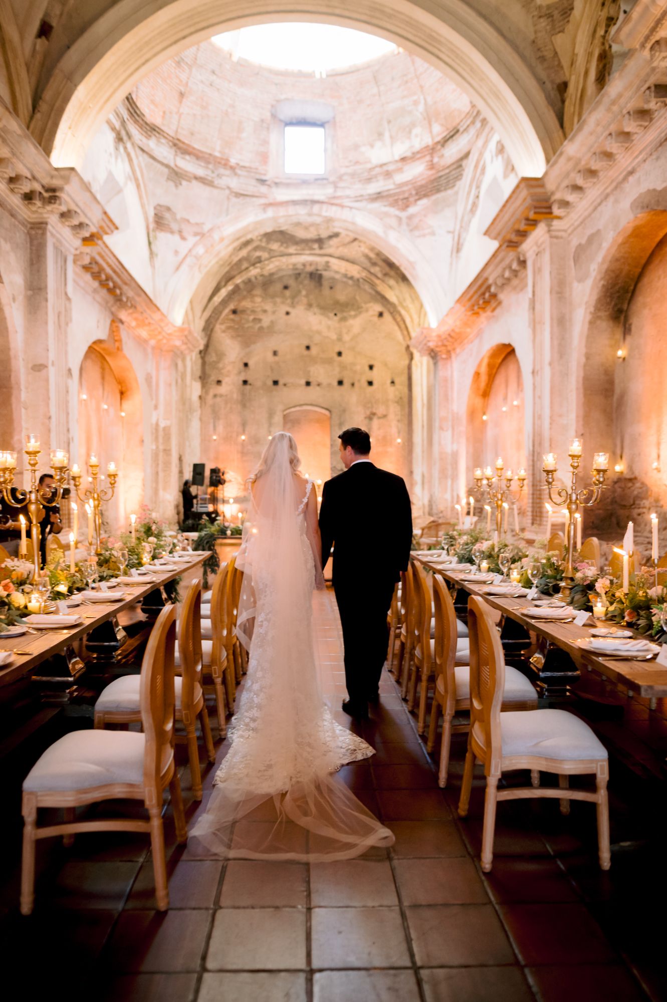 Wedding celebration in cathedral with vaulted ceilings and elegantly decorated reception tables.