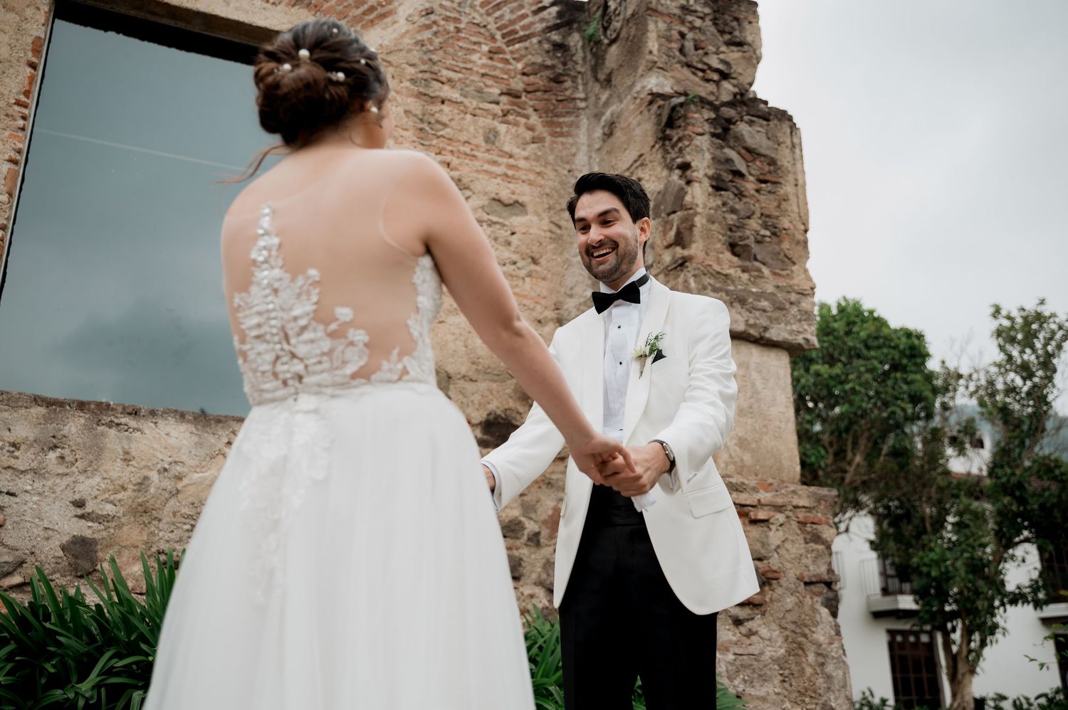 Bride and groom share an intimate moment at a rustic stone venue during their wedding photoshoot.