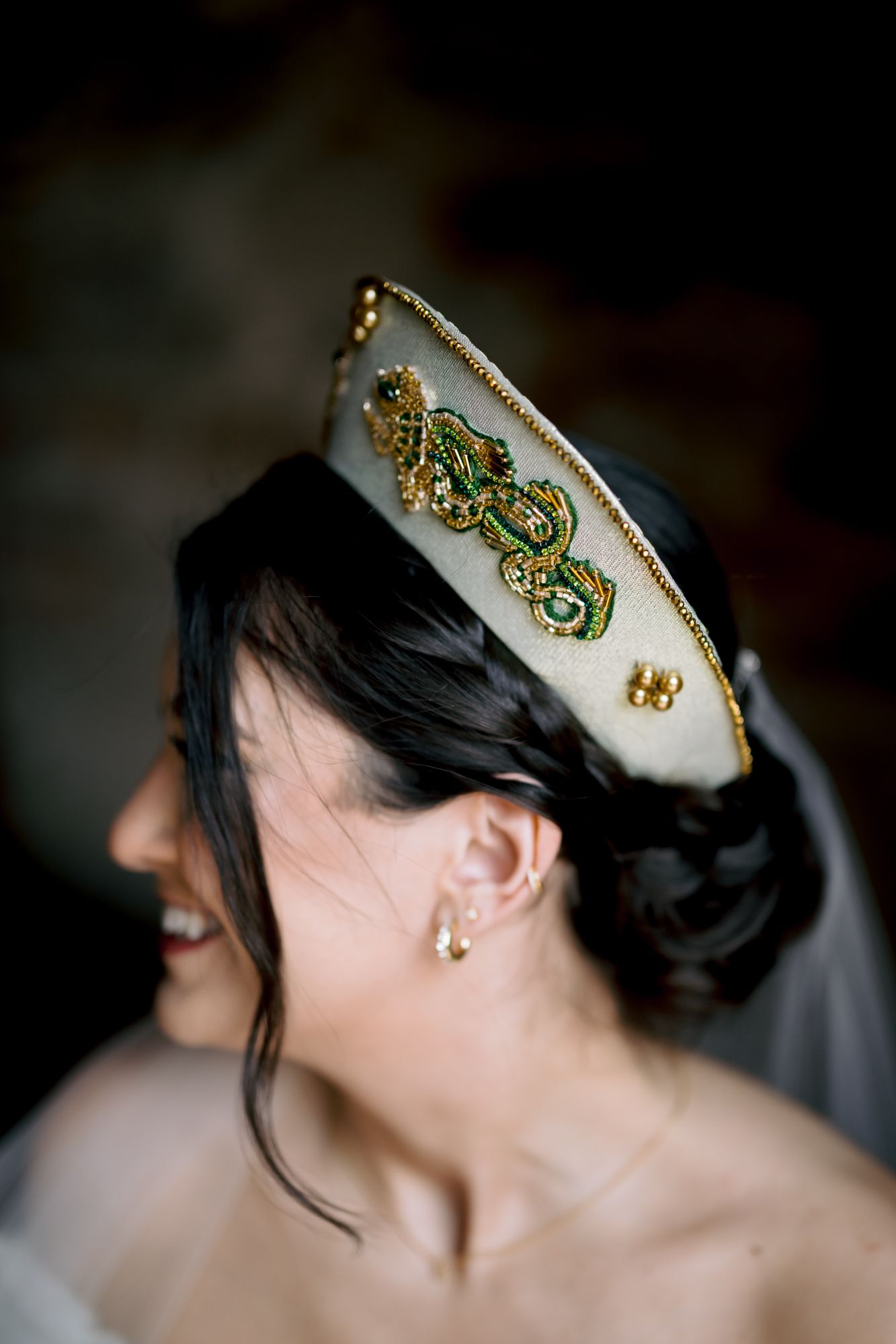 Detailed shot of ornate white and gold nautical-themed bridal cap with veil.