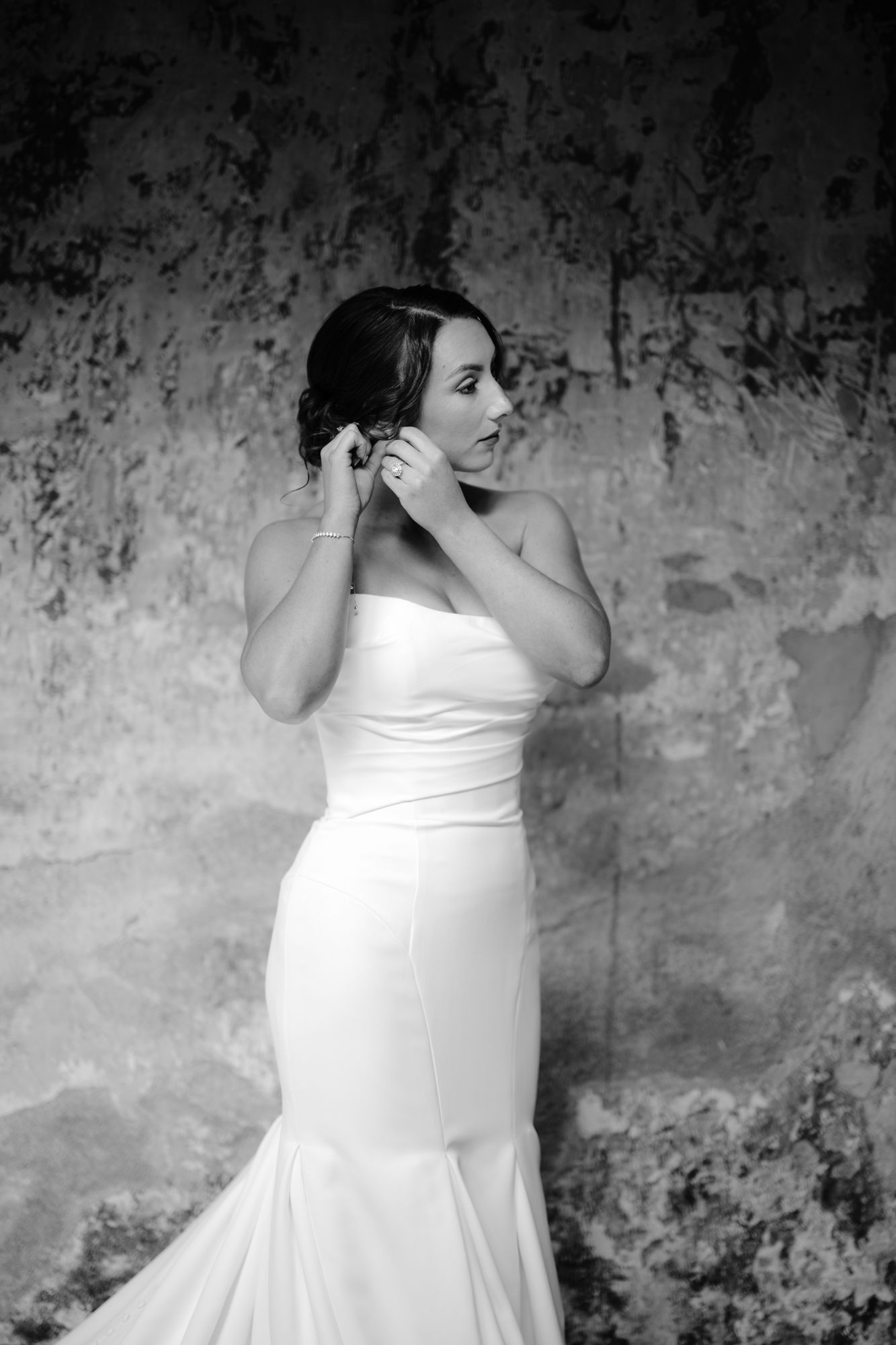 A classic black and white bridal portrait against a textured wall.