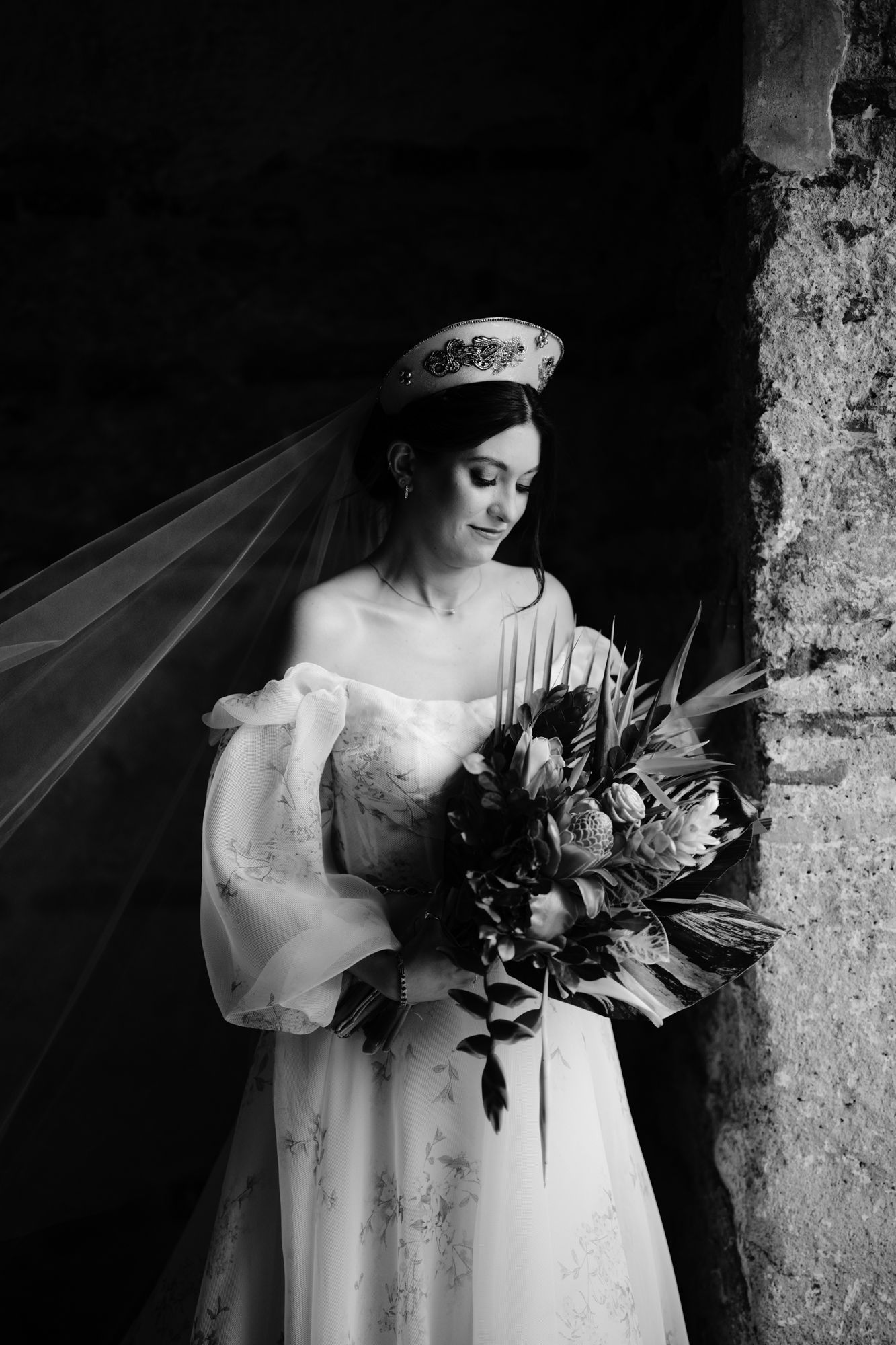 Elegant black and white bridal portrait with detailed lace dress and statement bouquet.