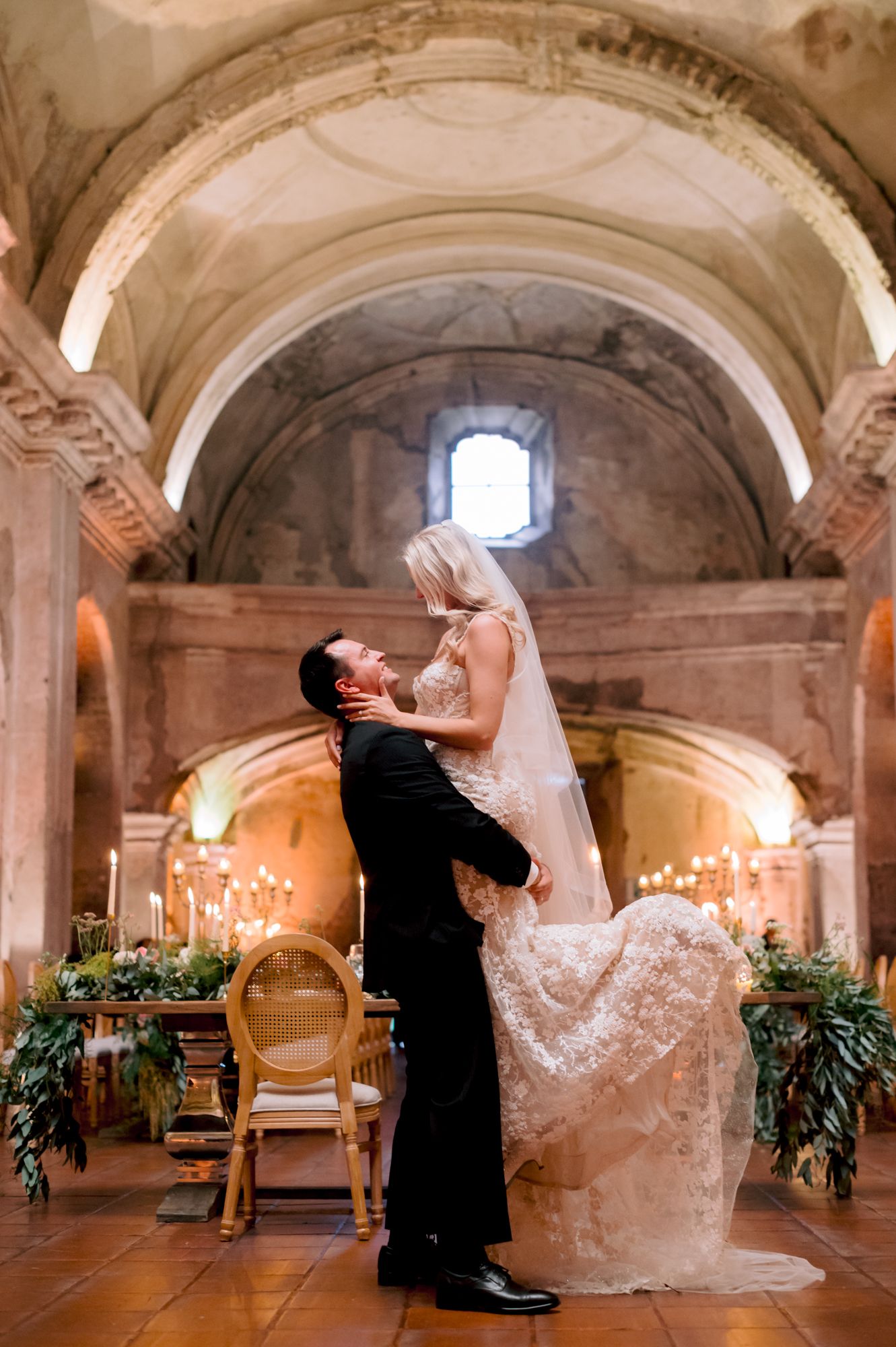 Romantic dance pose in historic church venue with vaulted ceilings and elegant decor.