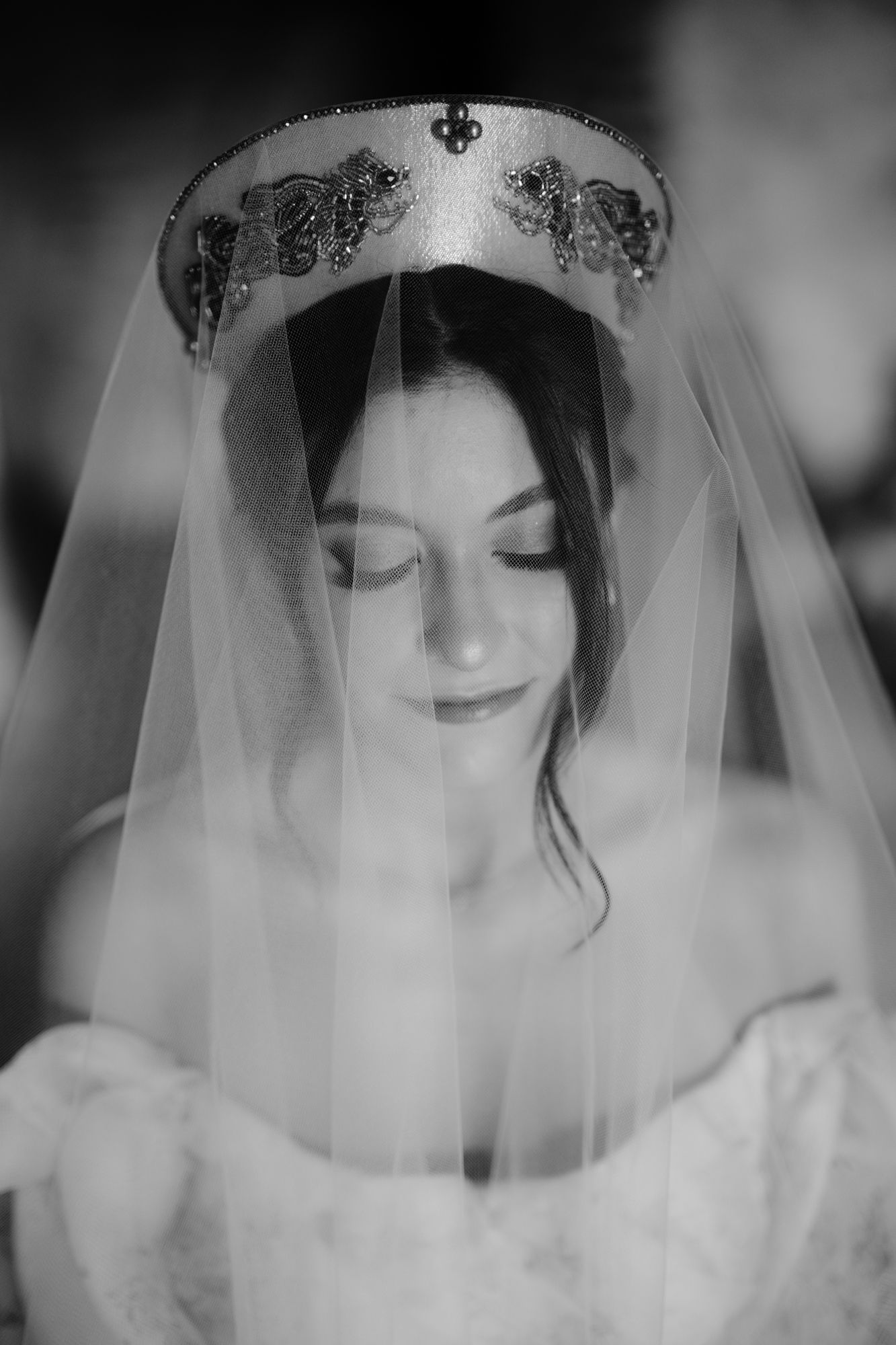 Dramatic black and white portrait showcasing an ornate bridal crown and delicate veil details.