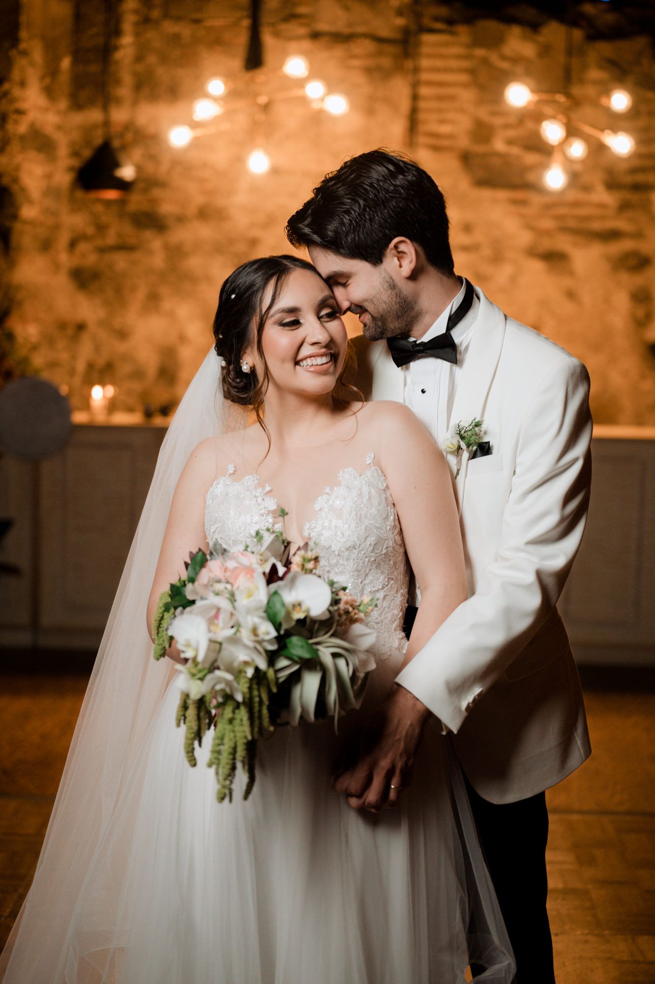Intimate wedding moment captured in a rustic venue with warm lighting and stone walls.