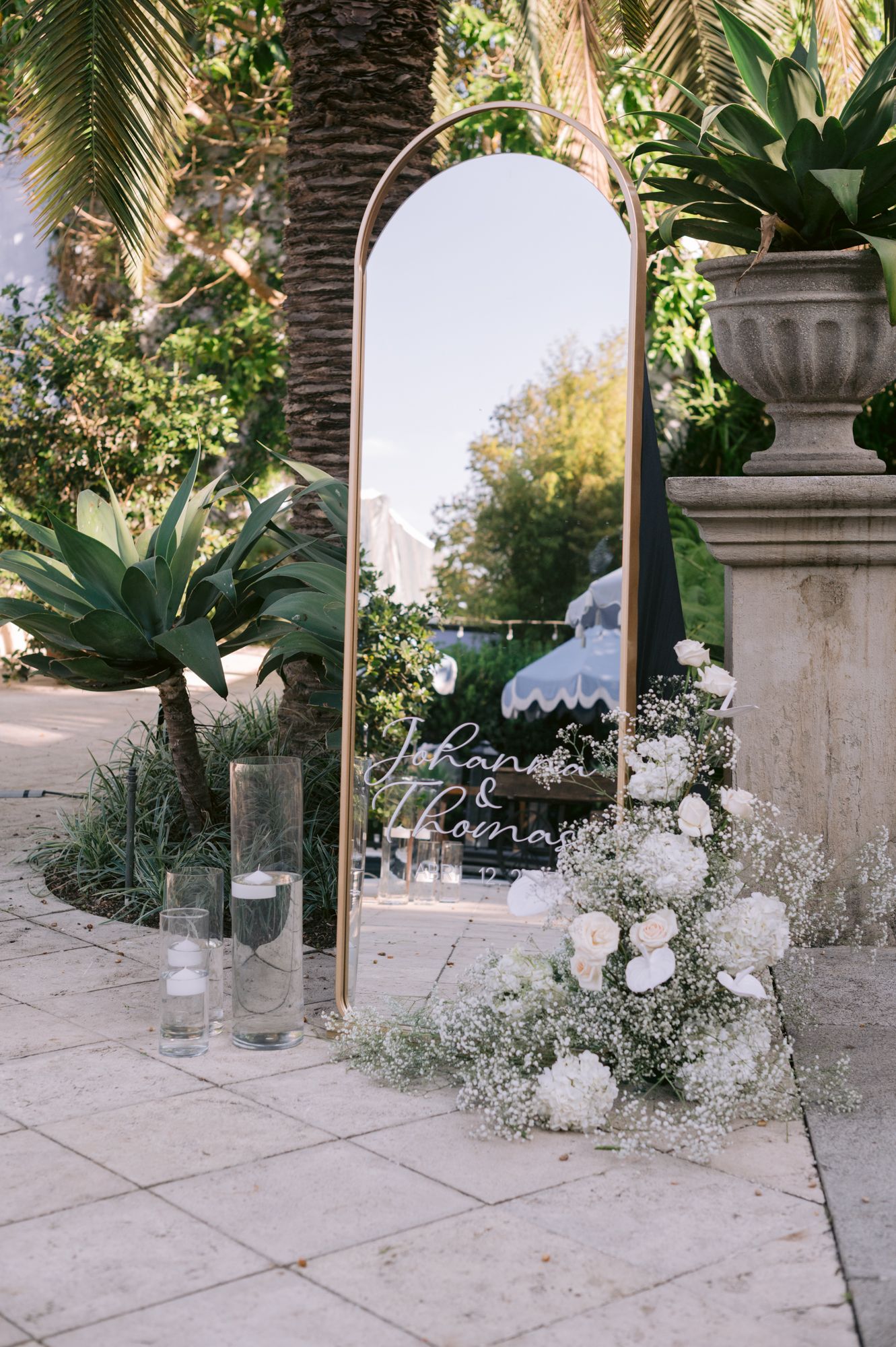 Decorative gold mirror and floral arrangements create elegant outdoor wedding display.
