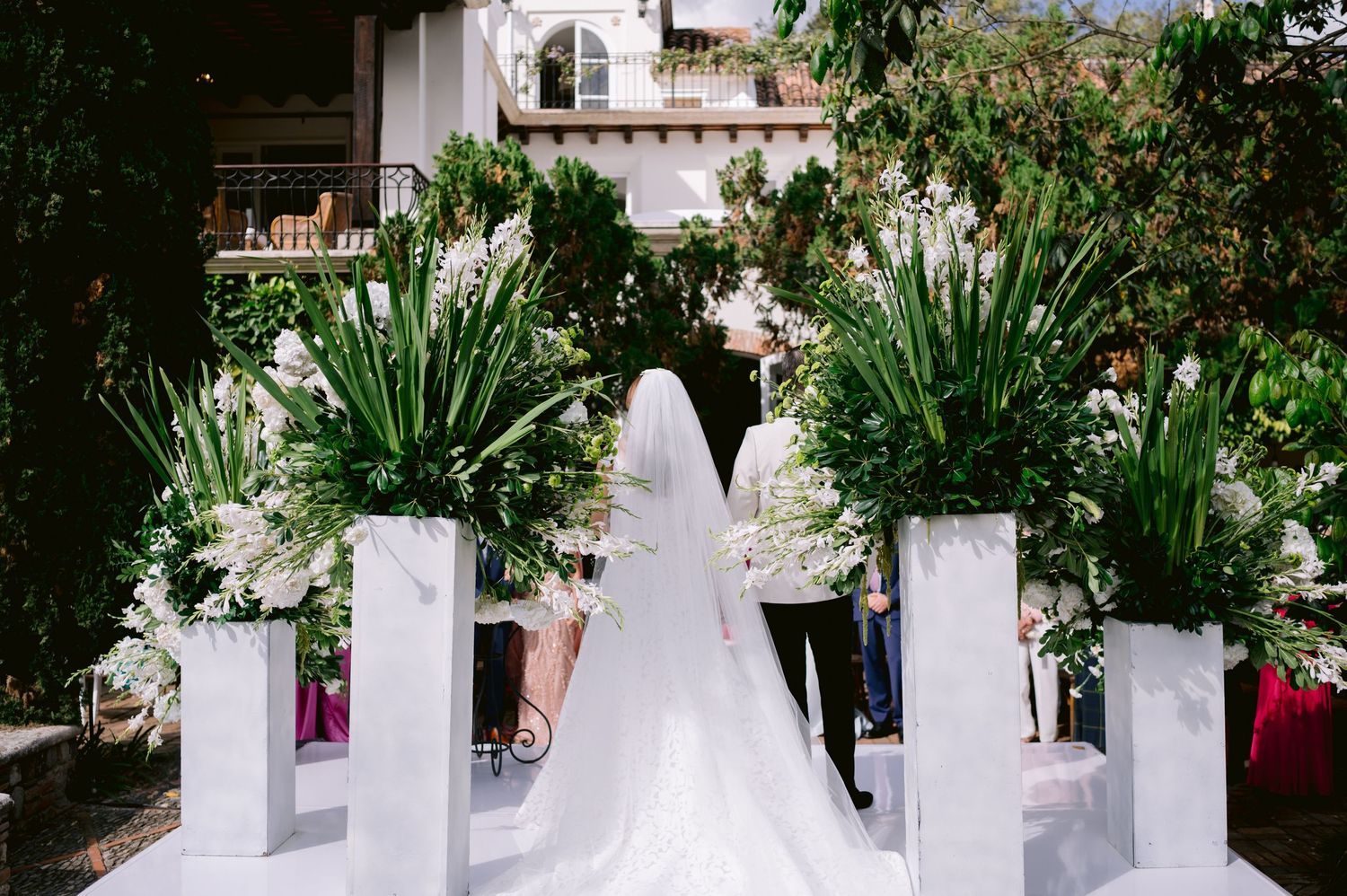 White floral wedding decorations and pillars arranged along an outdoor walkway.