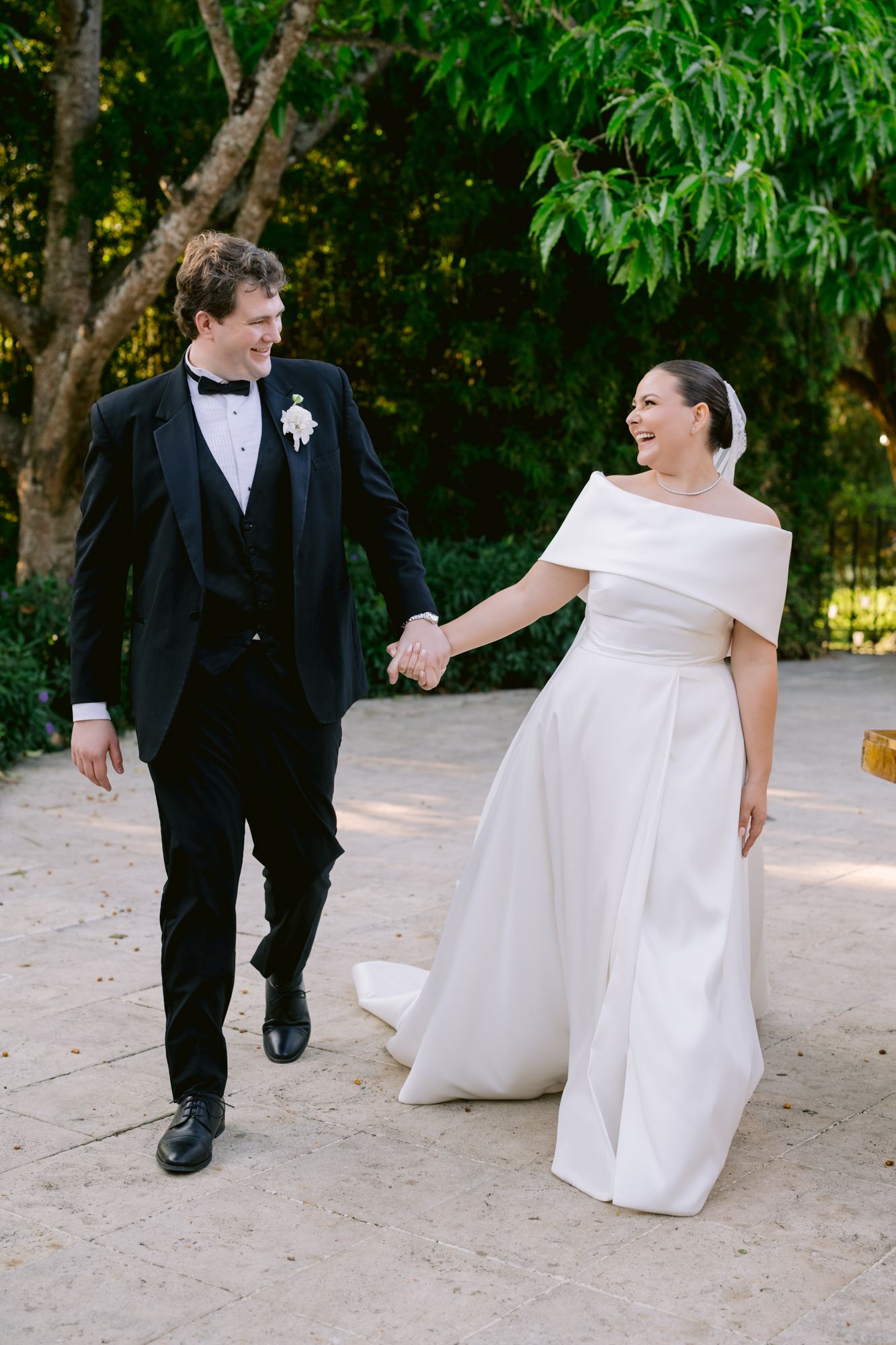 Happy newlyweds sharing a joyful moment while walking outdoors.
