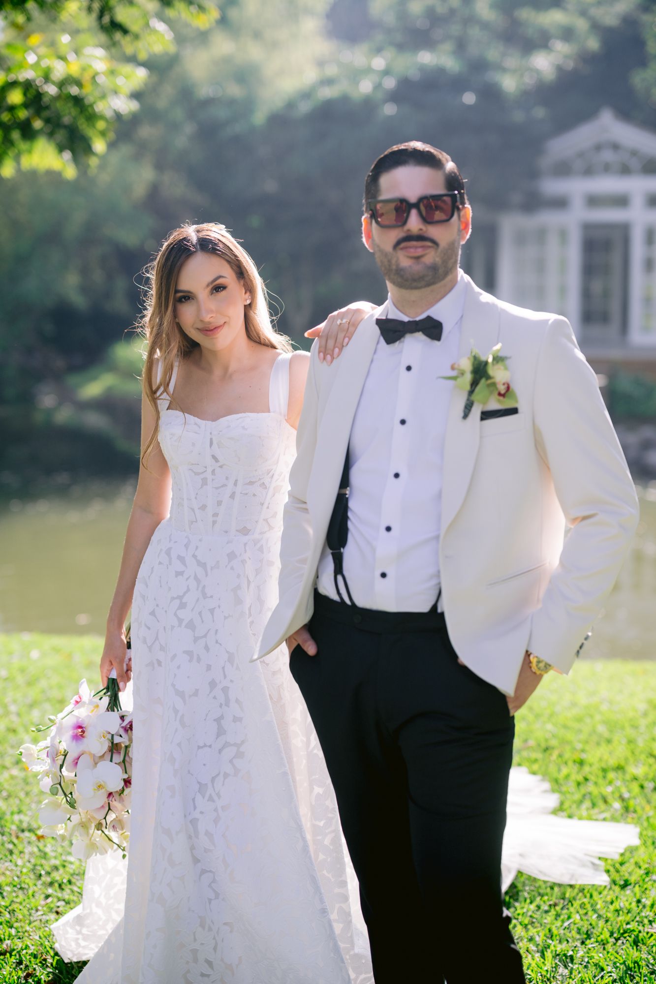 Wedding portraits in a garden setting with the couple in classic white and black formal attire.