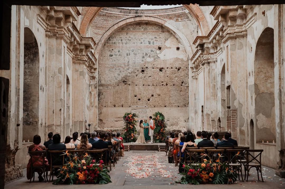 Intimate wedding ceremony in a historic stone chapel with rustic decor and floral arrangements.