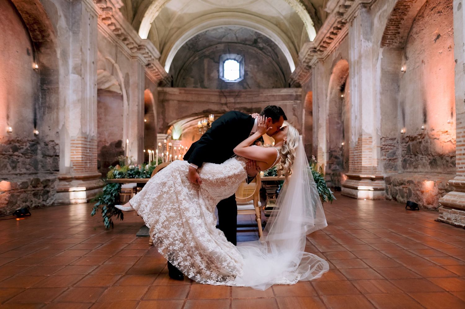 Dramatic dance dip pose inside historic church venue with elegant lighting and decor.