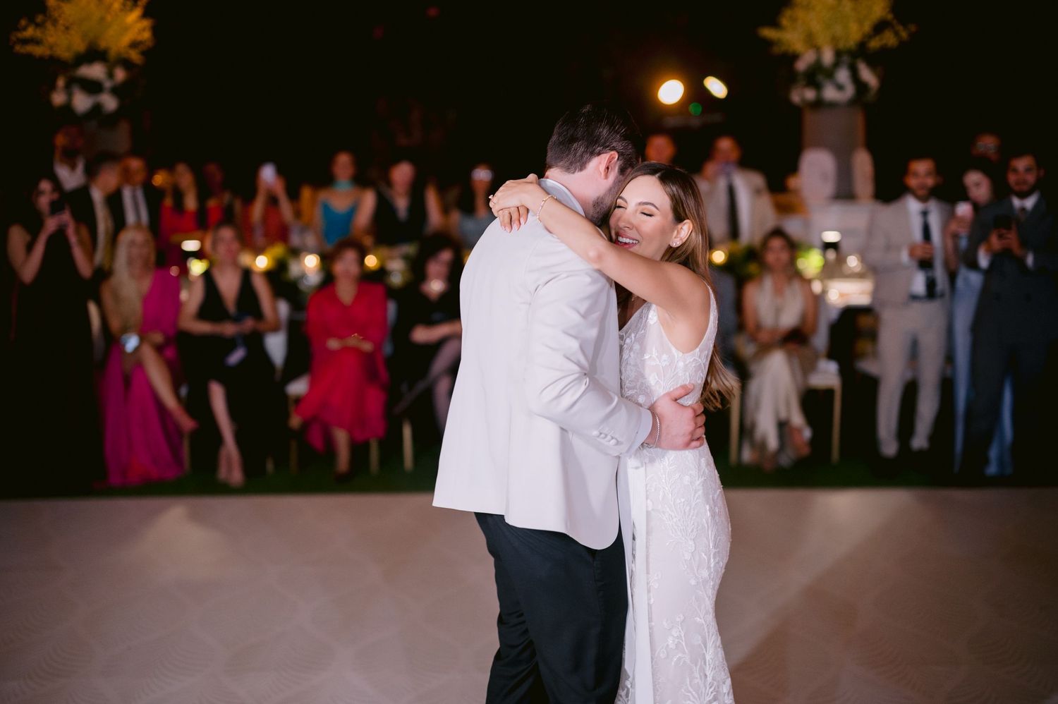 A couple shares a romantic dance together during their wedding reception celebration on the dance floor.