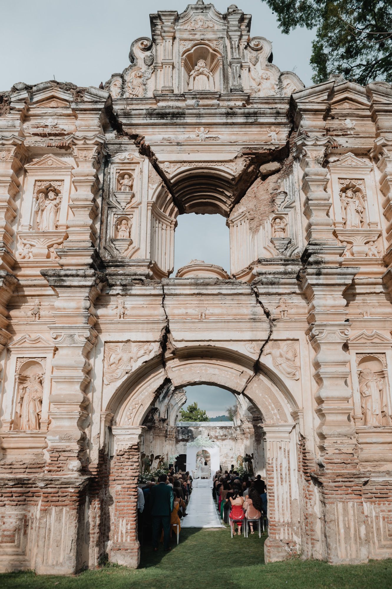 Ancient stone archways and ruins create a romantic wedding ceremony backdrop in a historic outdoor setting.