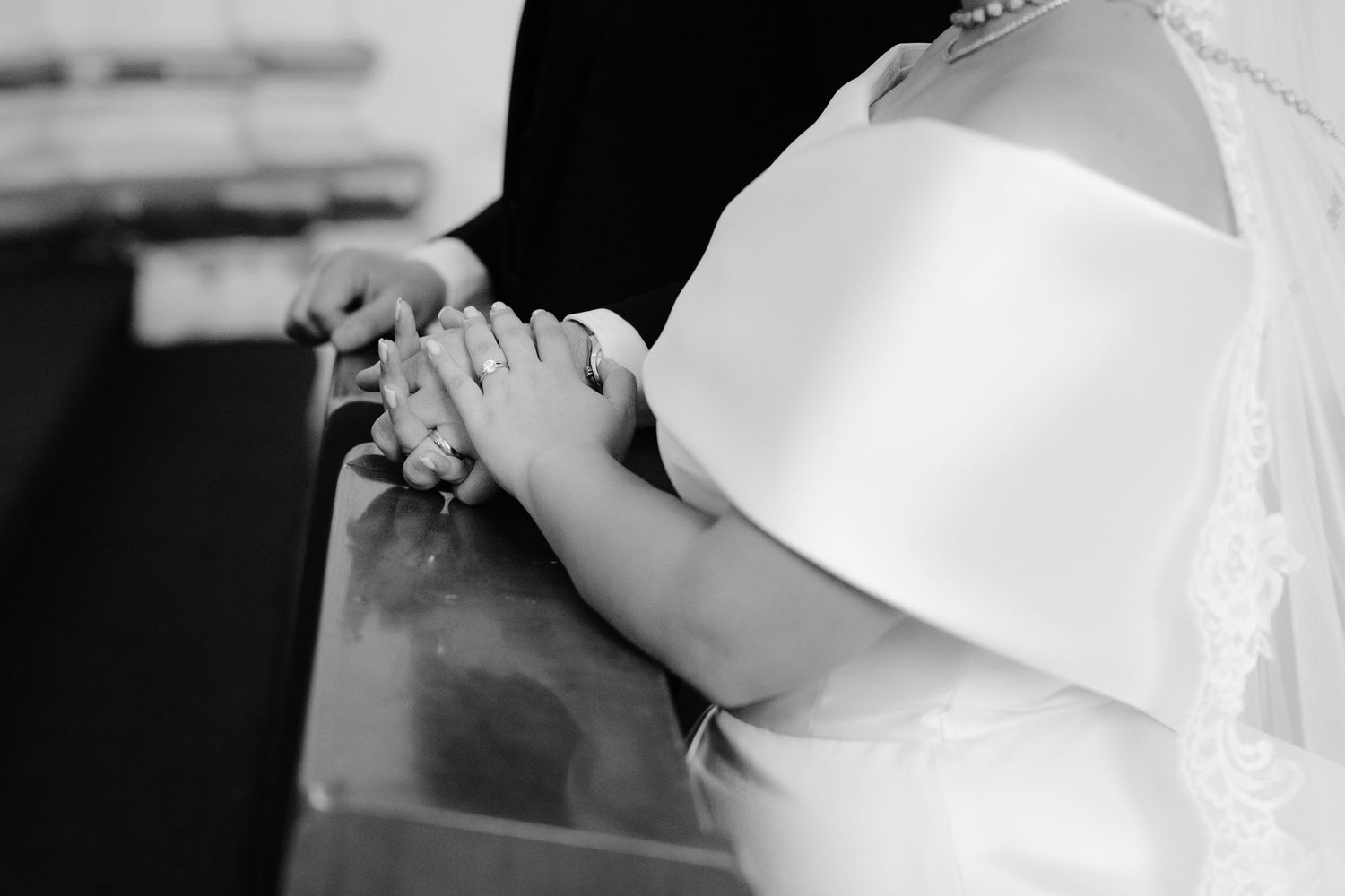 Close-up shot of clasped hands during a wedding ceremony.
