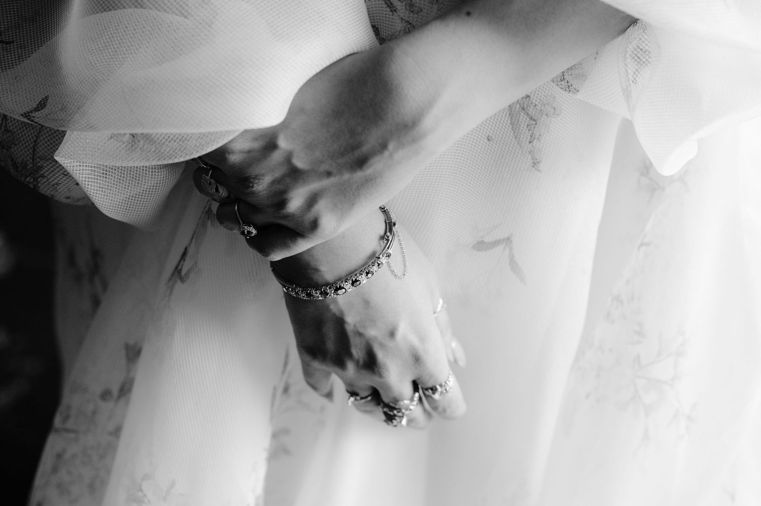 Close-up detail shot of delicate lace and beading on a white wedding dress.