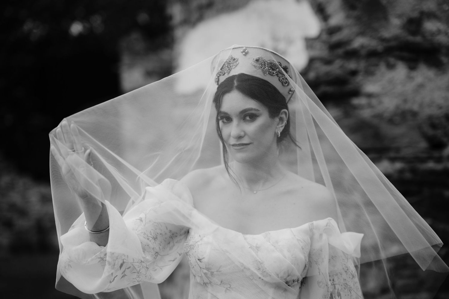 Classic black and white bridal portrait with ethereal veil and off-shoulder gown.