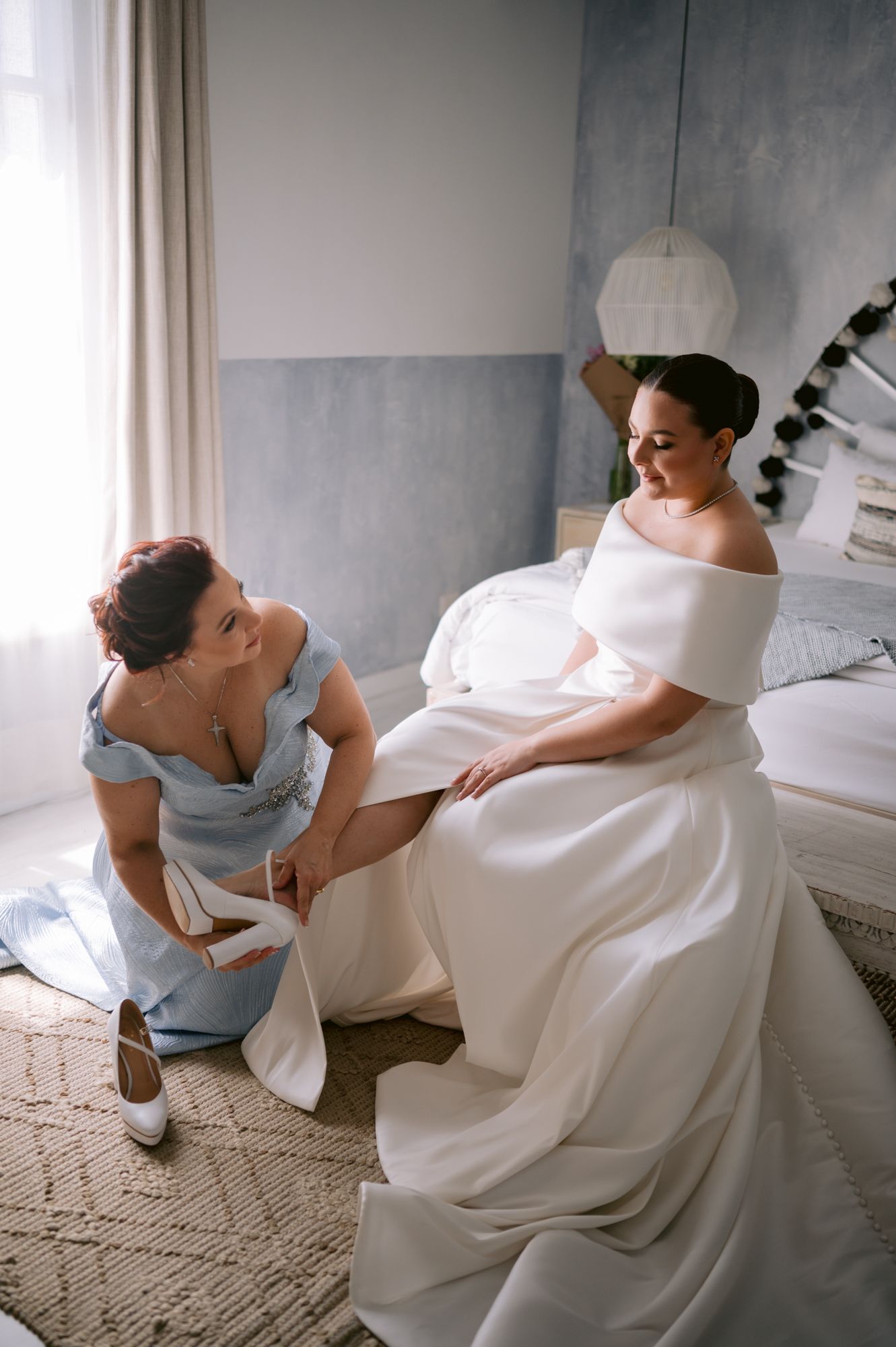 Intimate wedding preparation moment in a softly lit room with modern decor.