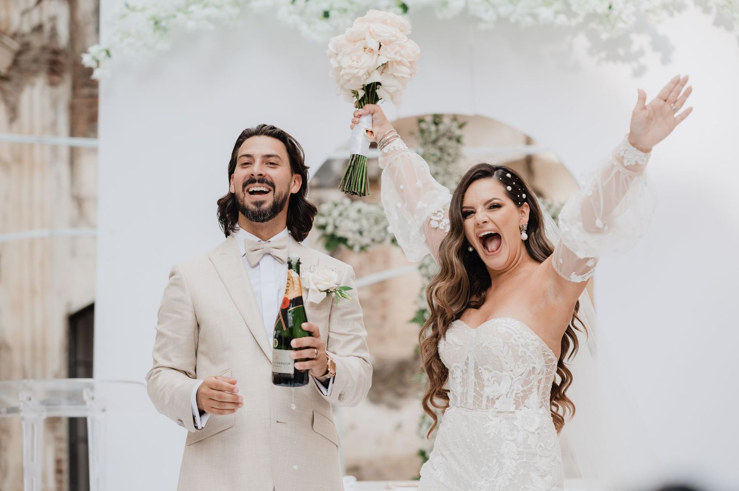 Joyful wedding celebration with sparklers creating magical light trails in an outdoor courtyard.