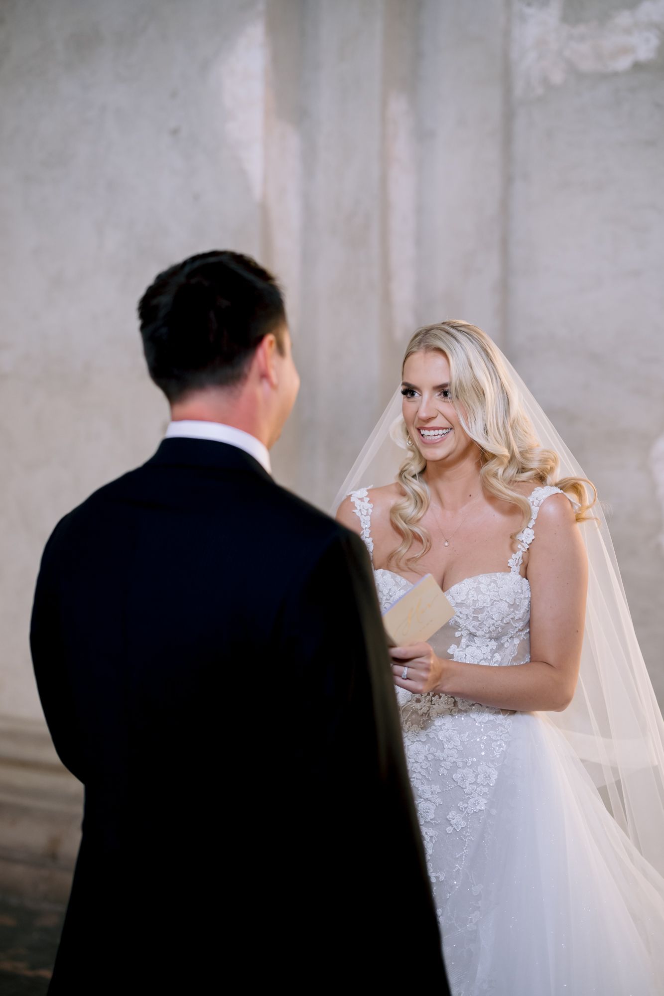 Candid wedding moment shows joyful expression in historic venue.