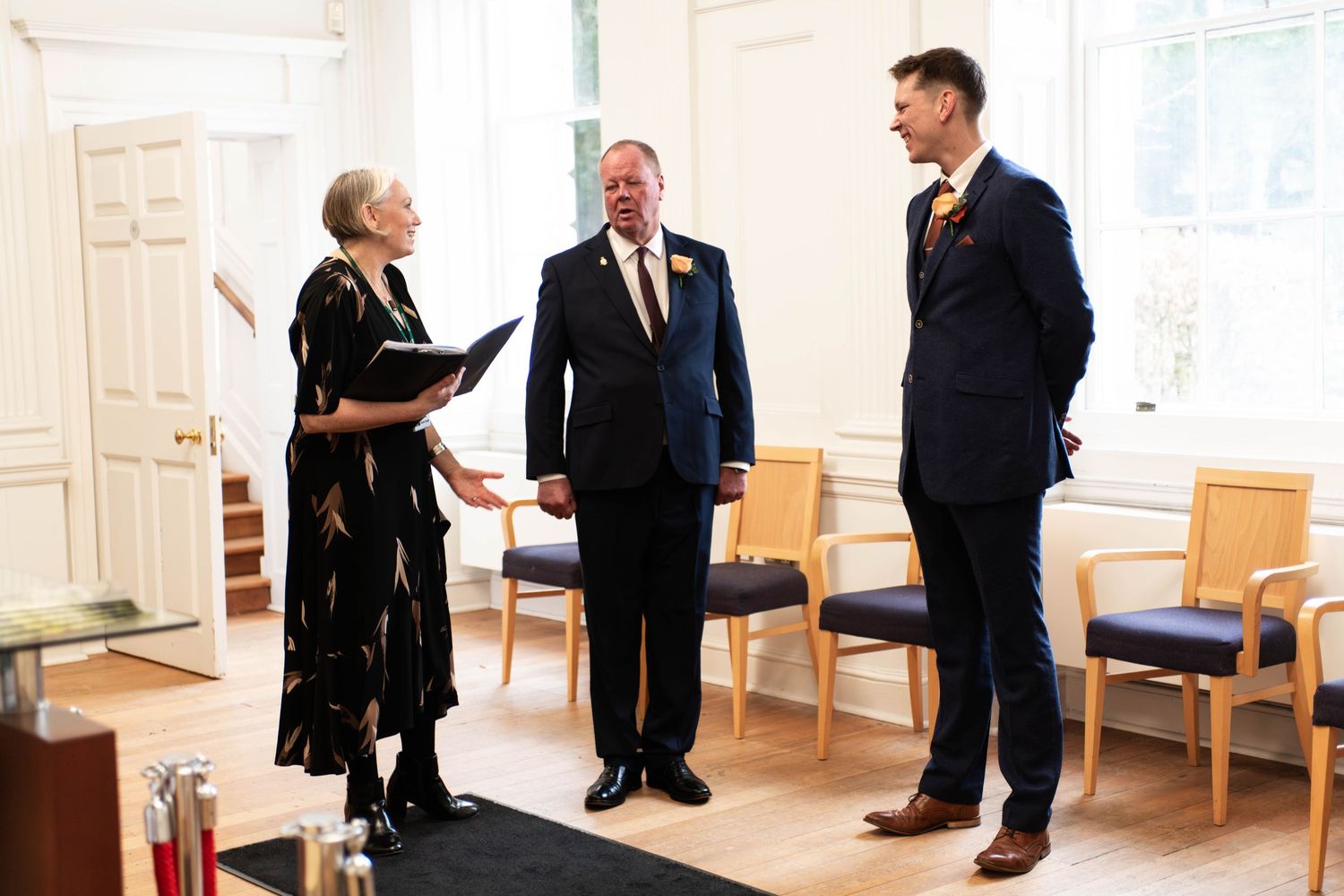 Officiant speaks privately with groom and bride's father before the ceremony.