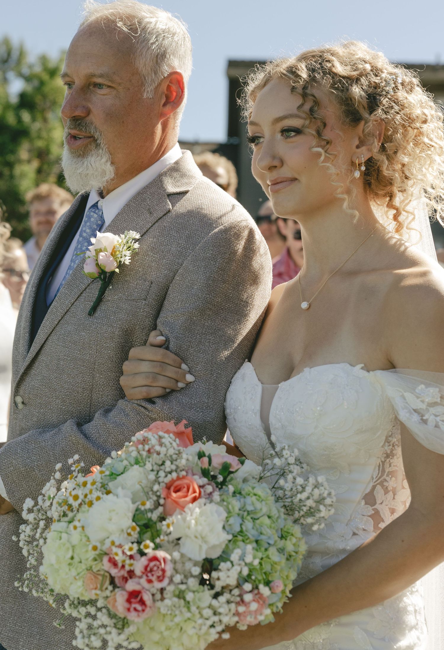 A tender wedding moment captured in a sequence of gentle embraces outdoors with soft pink and white floral bouquets.