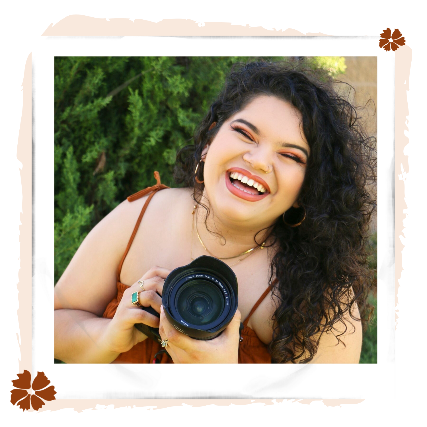 A portrait of Ashley, the owner of Ashley Rose Photography holding her camera while smiling