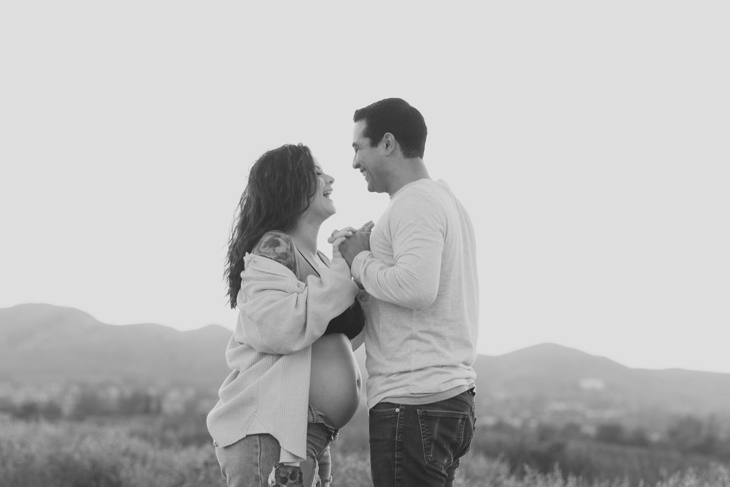 Pregnant woman and her husband holding hands during her pregnancy photo shoot