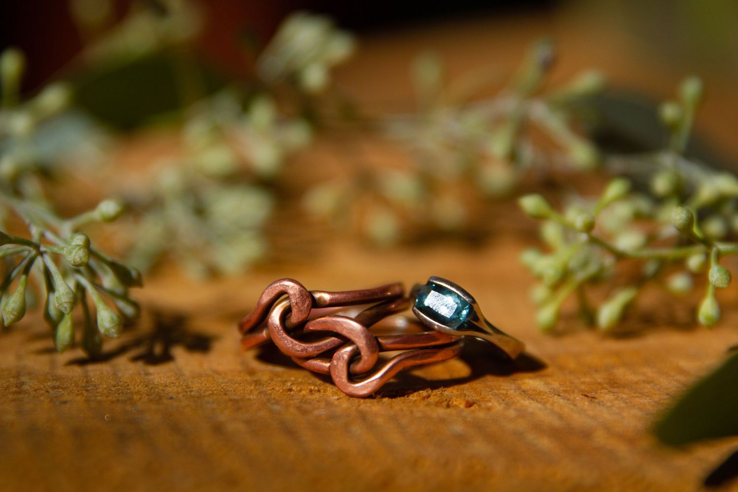 Grooms wedding band and brides wedding ring with florals in the background