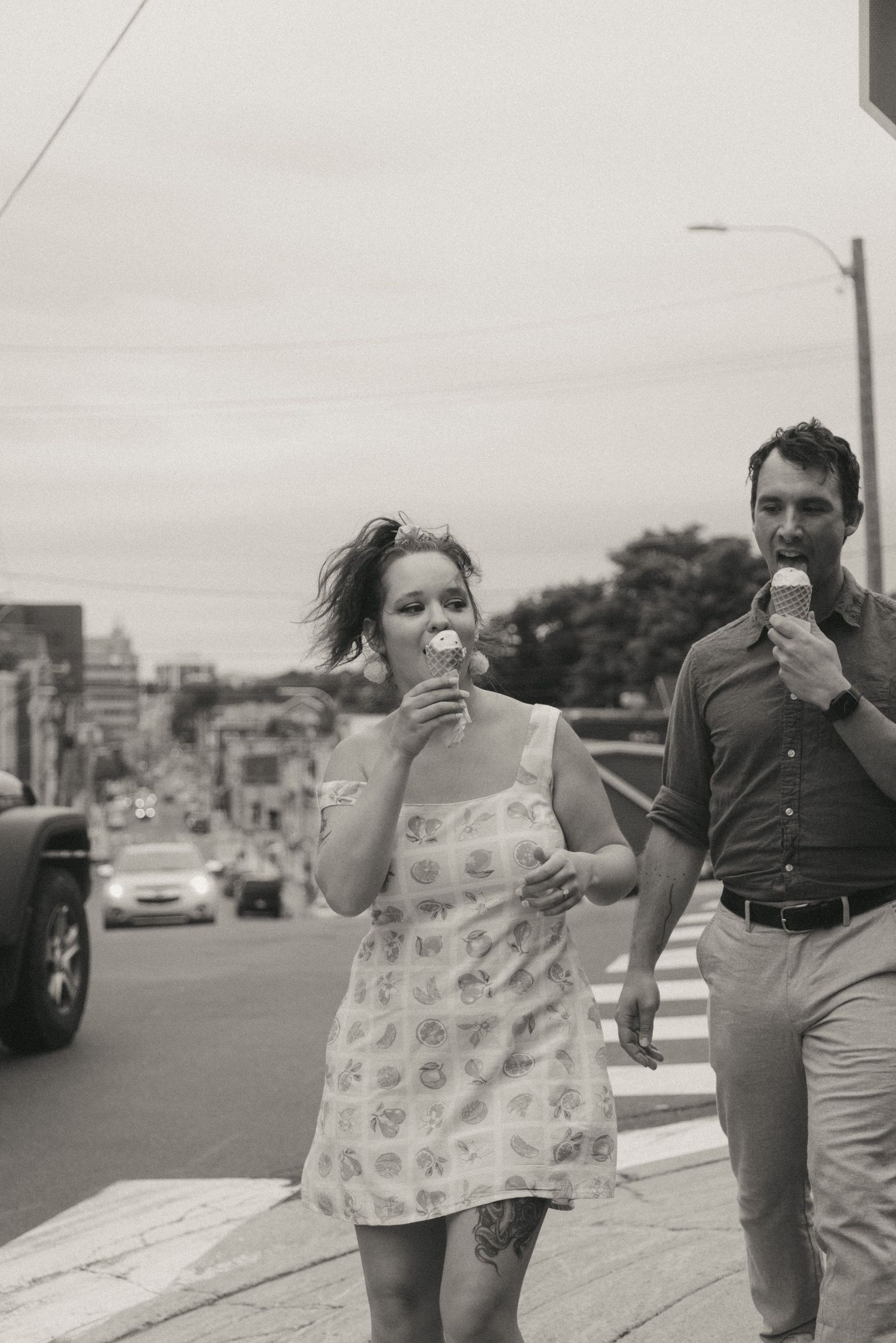 A couple walking down St. John's street while enjoying ice cream cones together by Newfoundland Wedding Photographer Kaitlyn Yvette