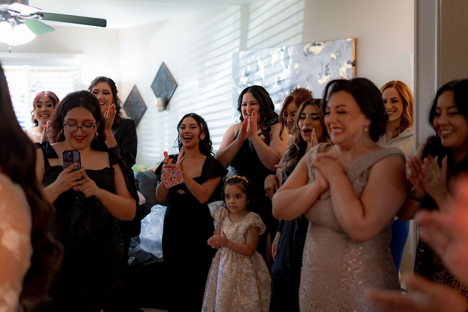 Wedding guests in formal attire react emotionally during ceremony.