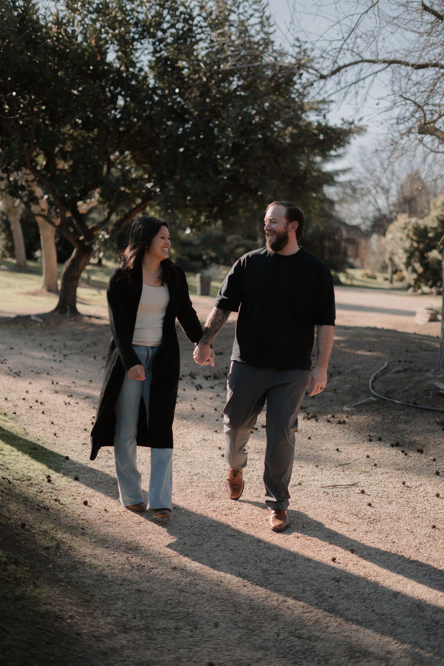 Couple walking together on a path through a scenic park.