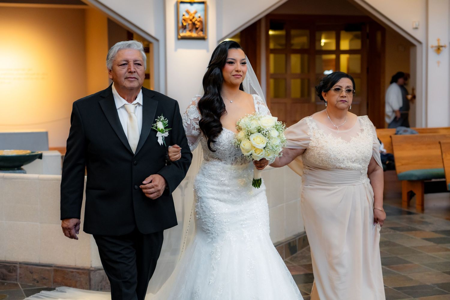 Wedding ceremony processional with white floral decorations and elegant church interior.