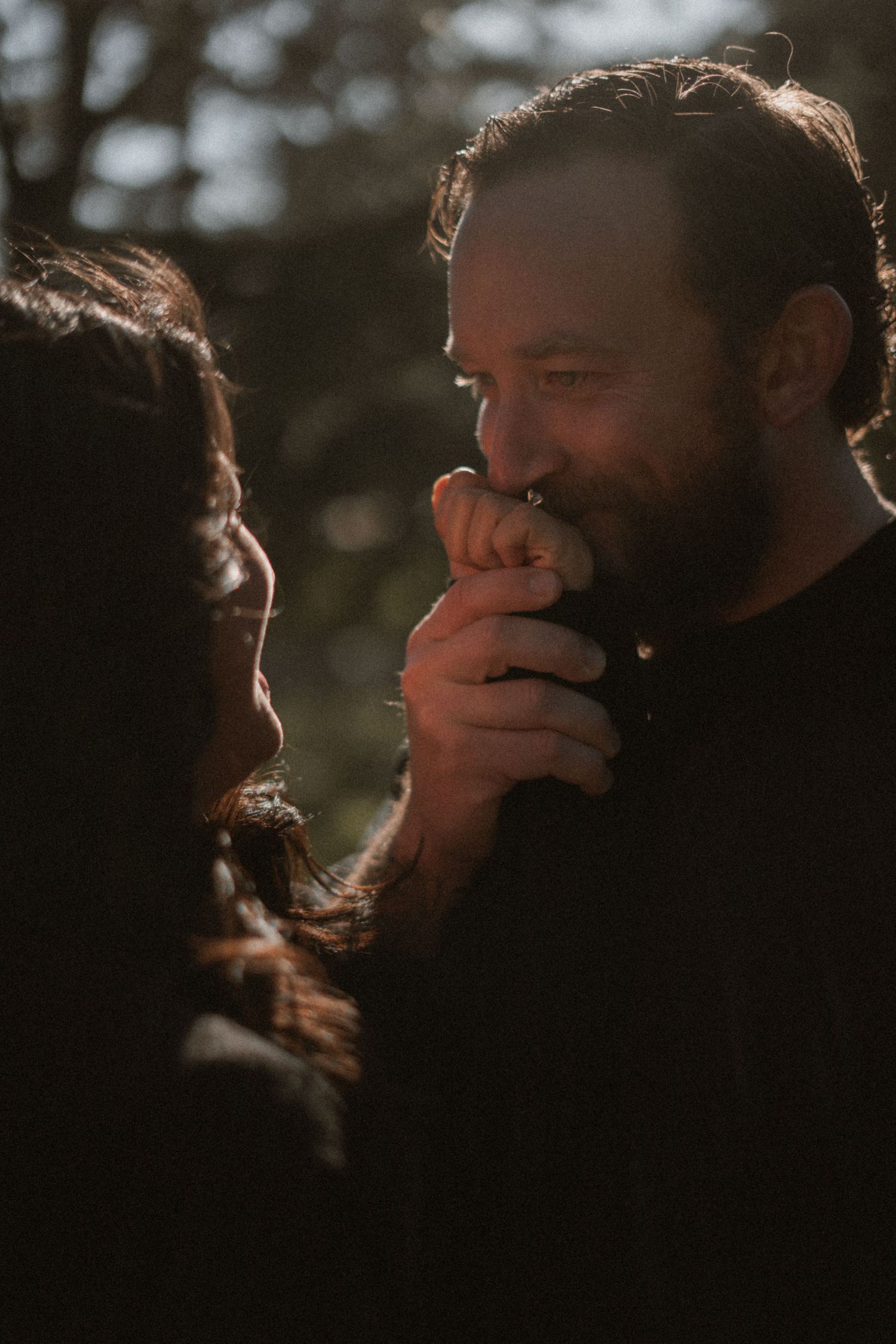 An intimate close-up of a couple sharing a tender moment in golden hour lighting.