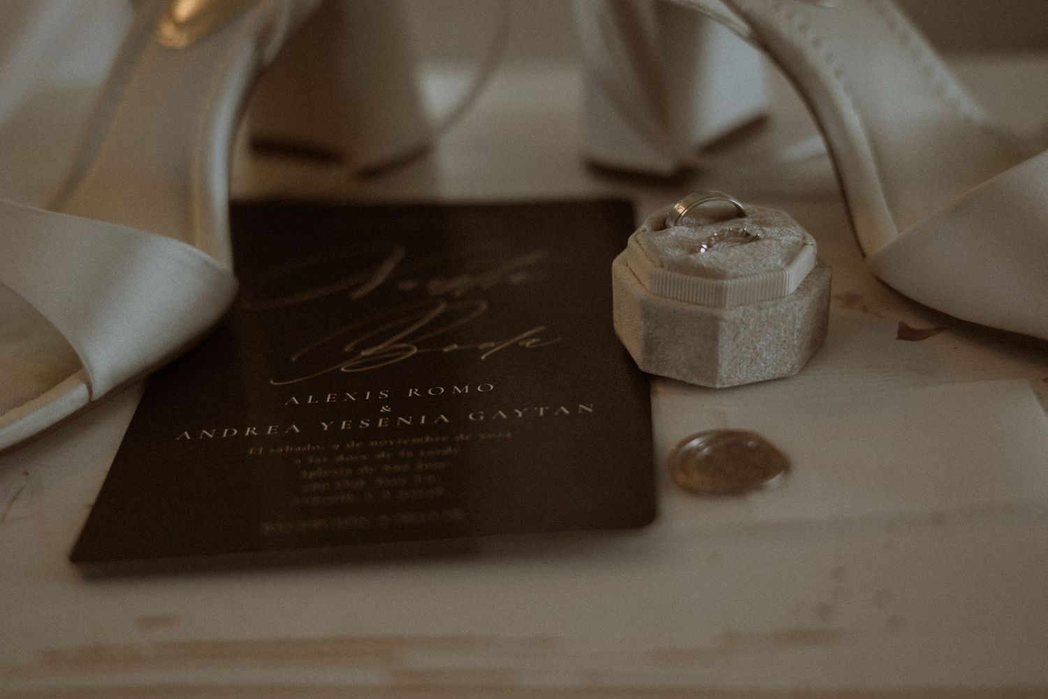 Wedding stationery with black cards and white ribbons arranged on light surface.