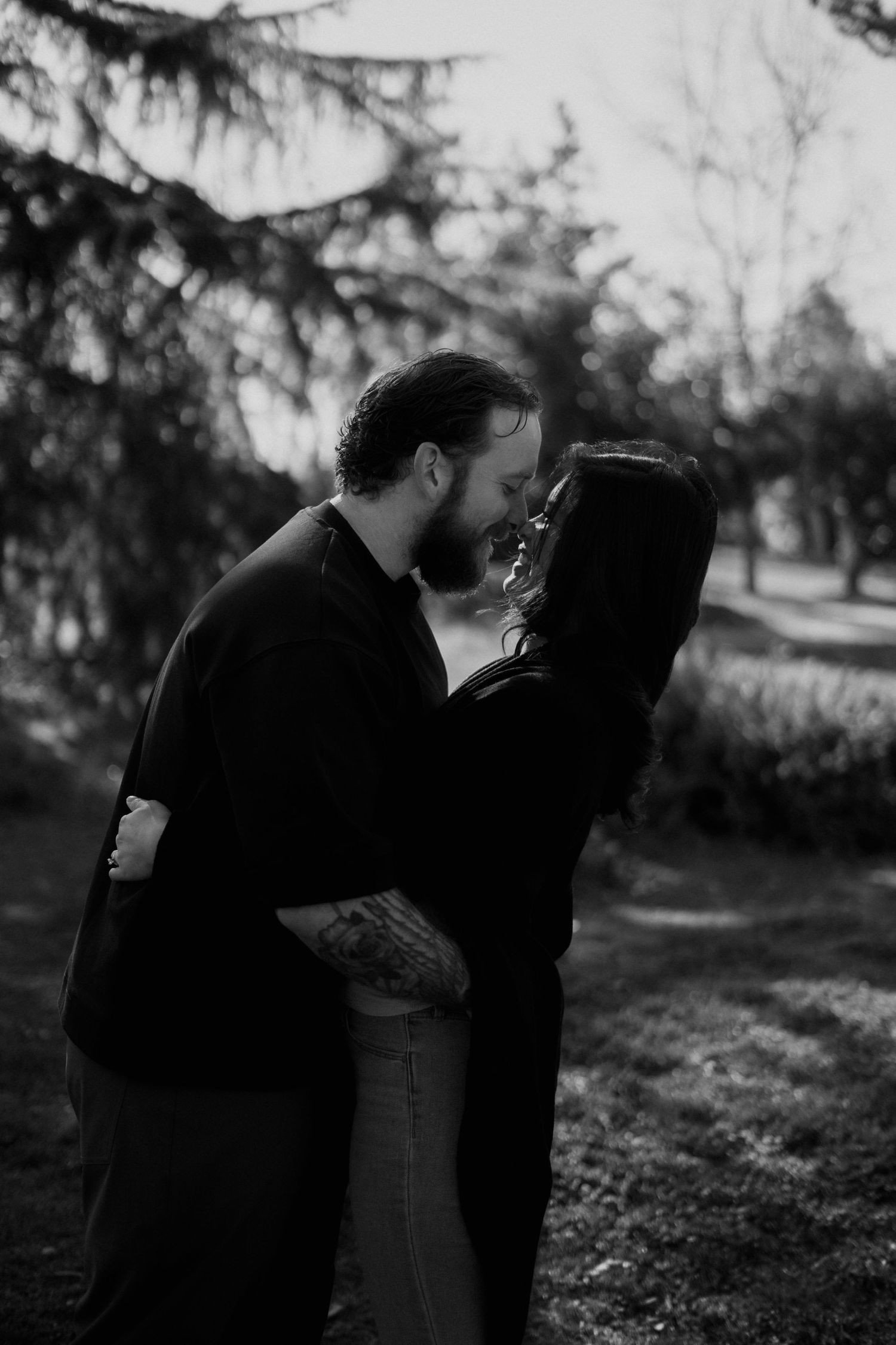 Artistic black and white couple's portraits captured in natural outdoor setting.