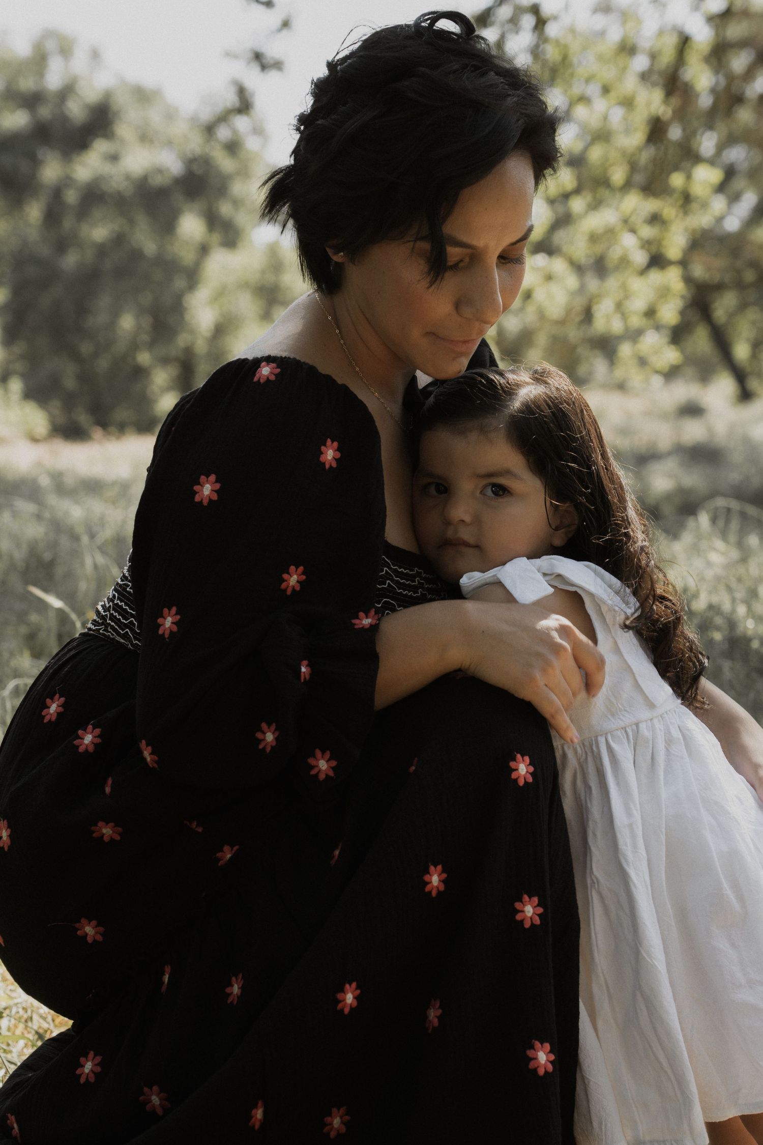 Tender moment captured between parent and child wearing contrasting black and white outfits.