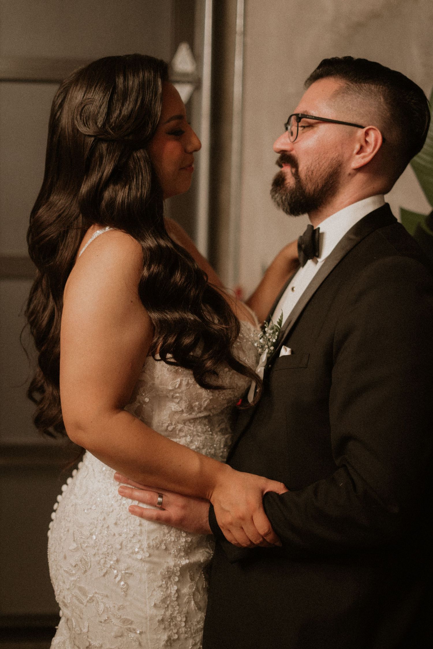 A romantic wedding moment captured in black and white showing a couple embracing in elegant attire.