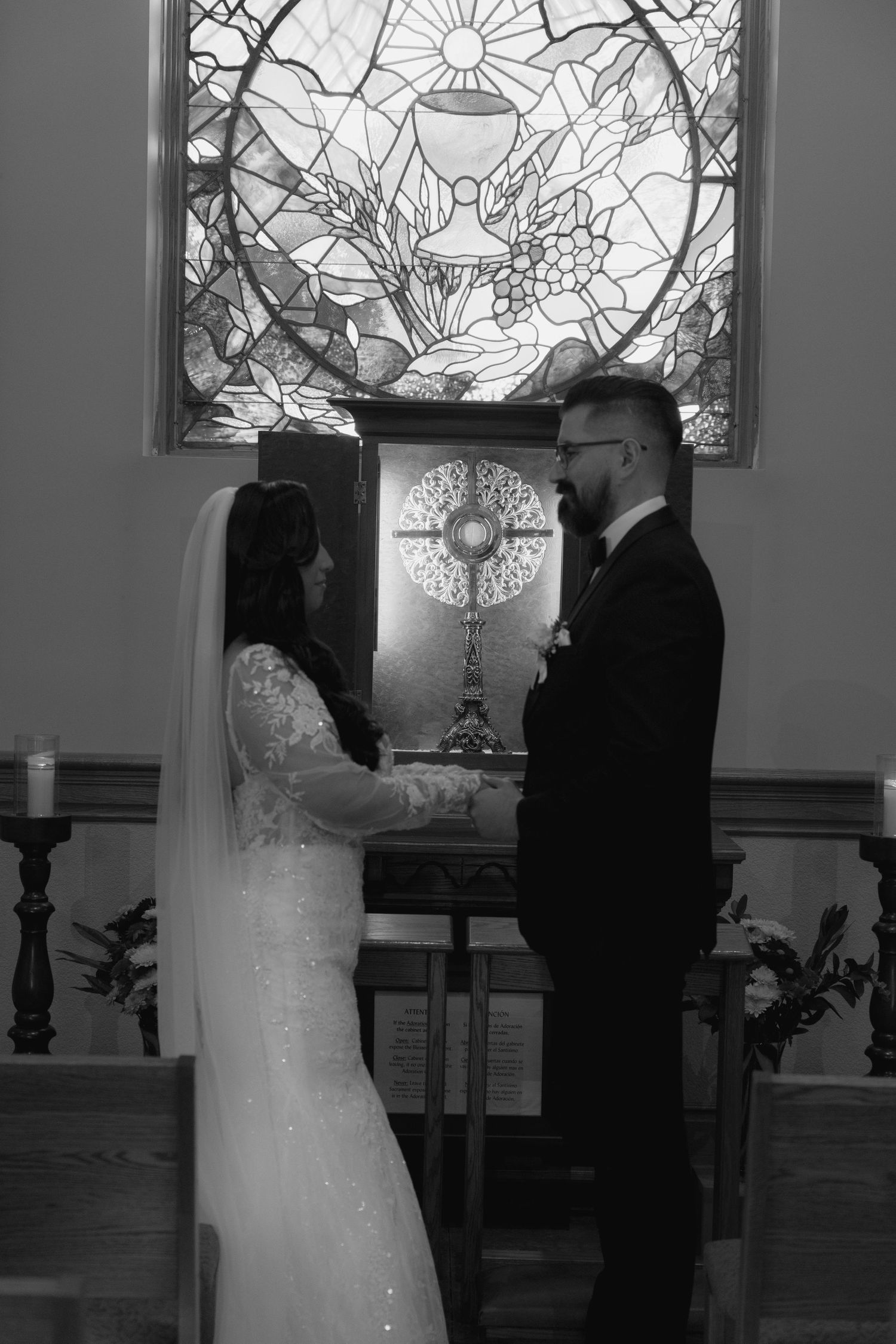 Black and white photos of a couple's intimate moments in front of stained glass windows.