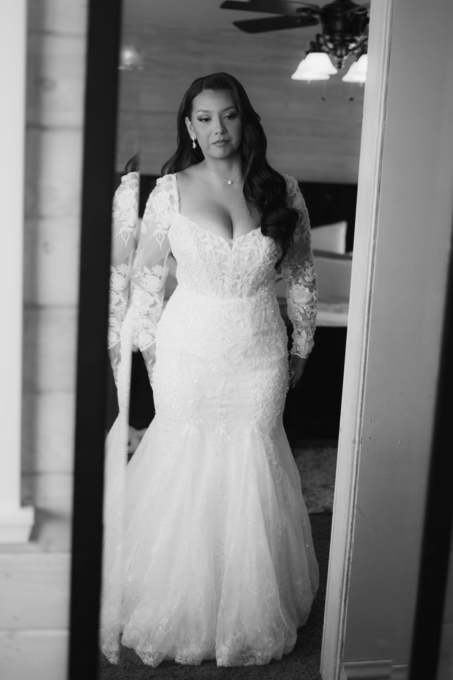 White lace wedding dress displayed in natural window light.