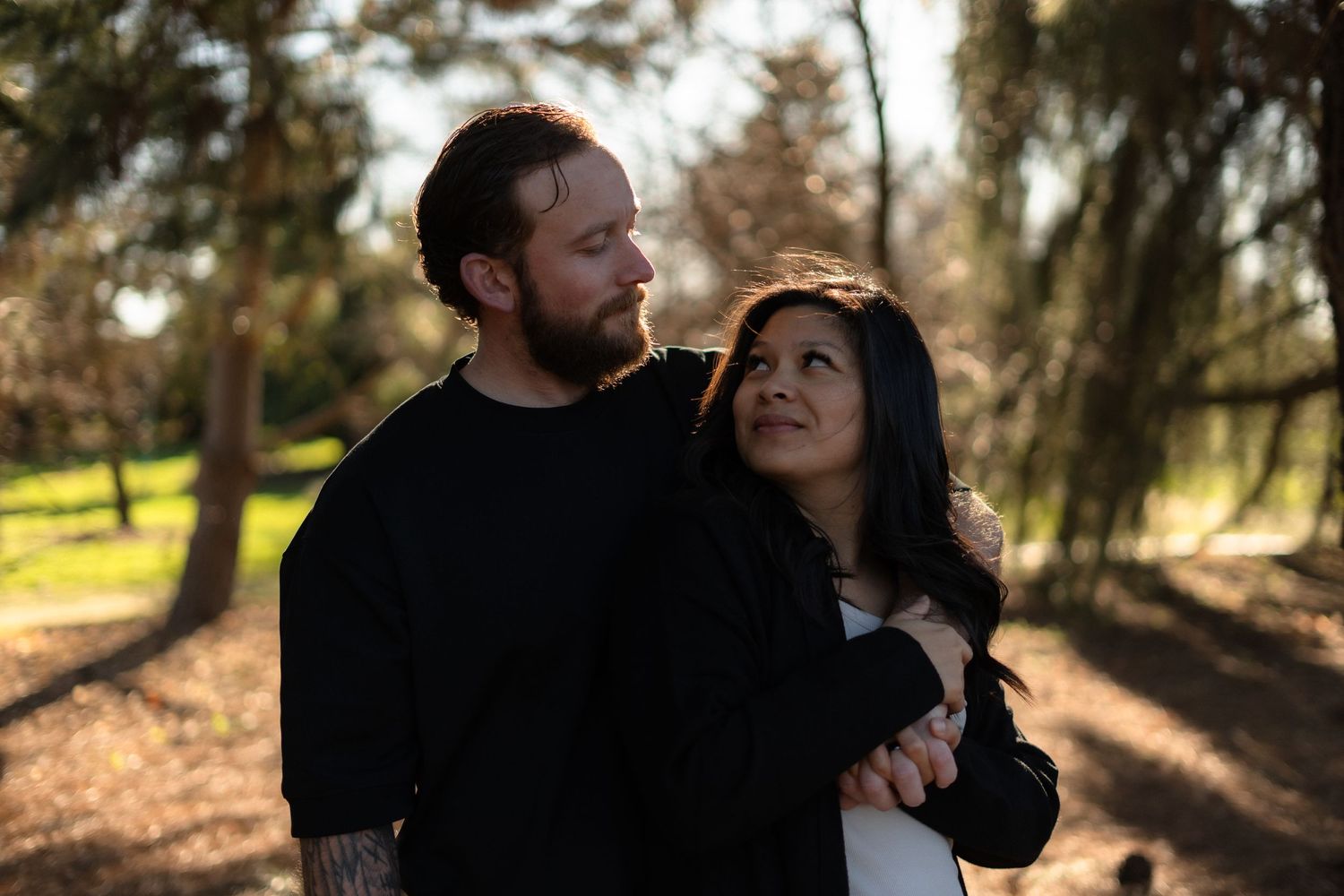Intimate couple portraits captured in a natural outdoor setting with soft lighting.