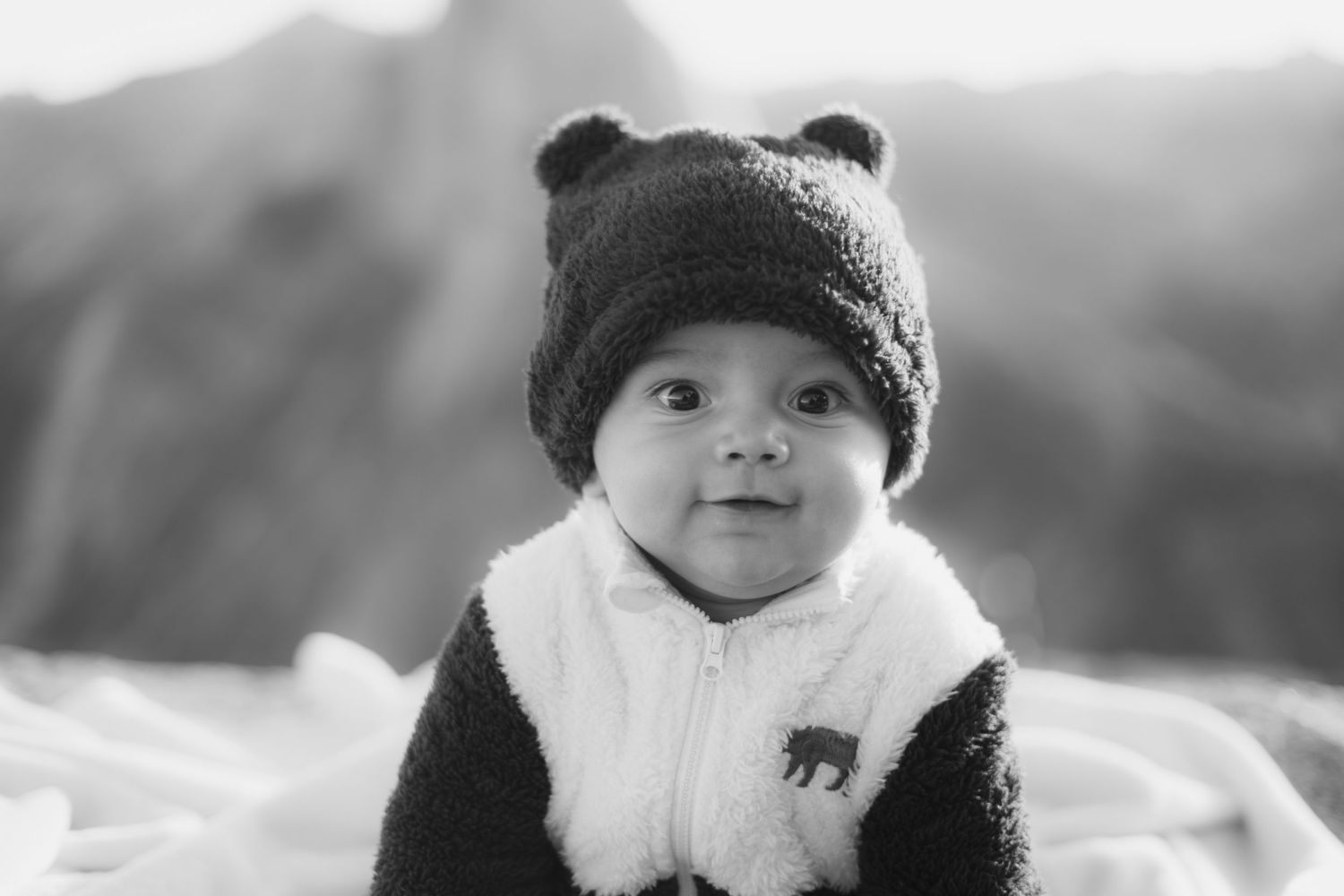 Child wearing a winter hat and warm clothing outdoors.