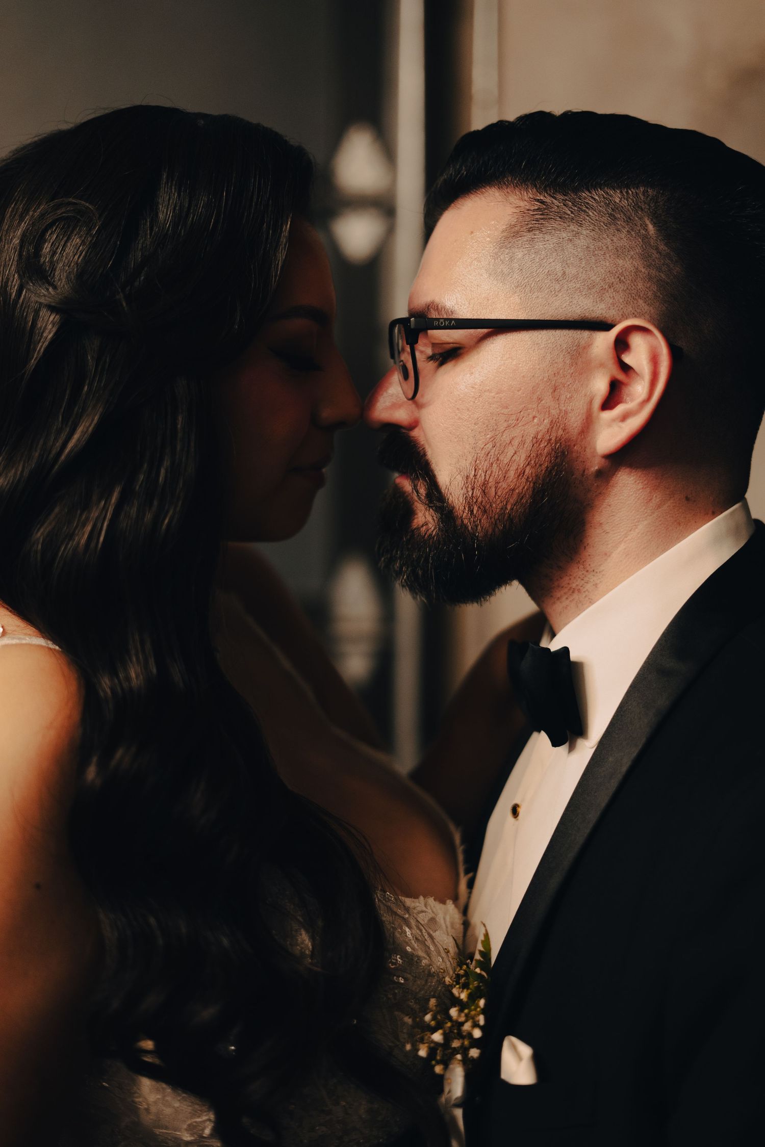 Moody black and white portrait of a couple sharing an intimate moment at their wedding.