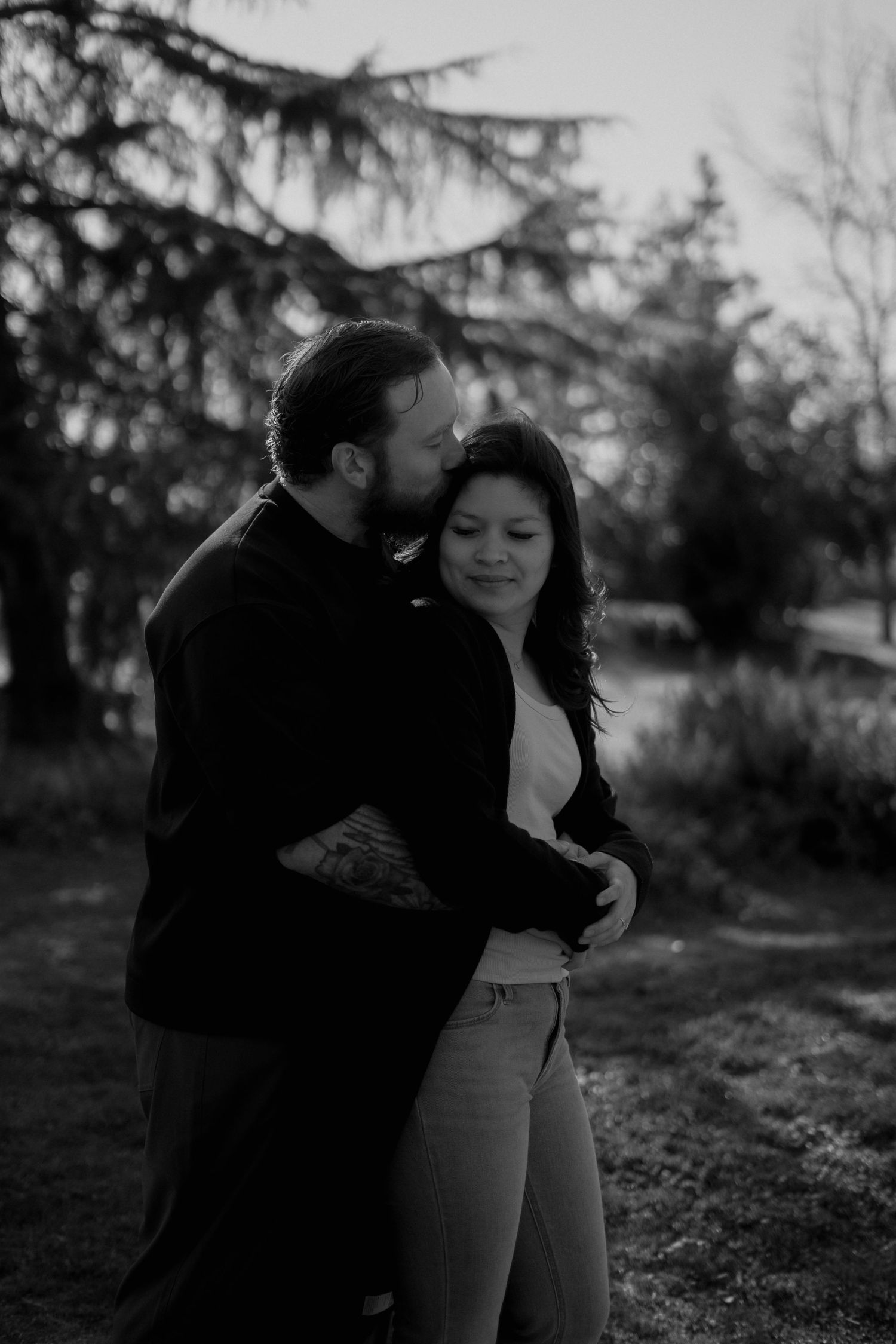 Intimate couple's portrait session captured in moody natural lighting.