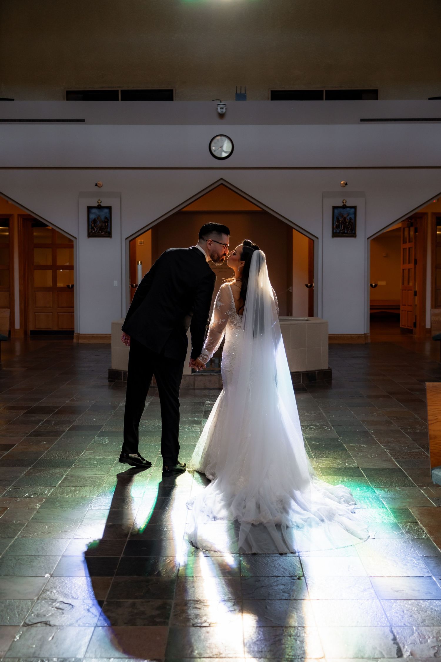 Artistic wedding photos capturing shadows and light of a couple in a church interior.