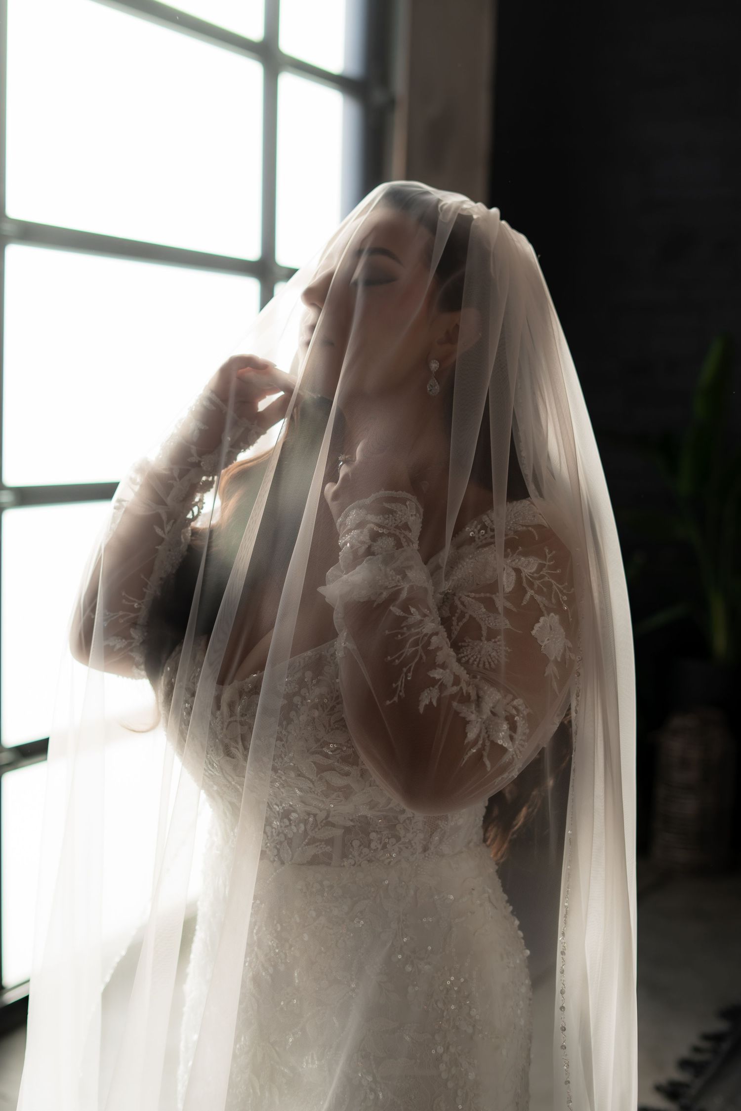 Ethereal bridal portrait with soft natural light filtering through a delicate veil.