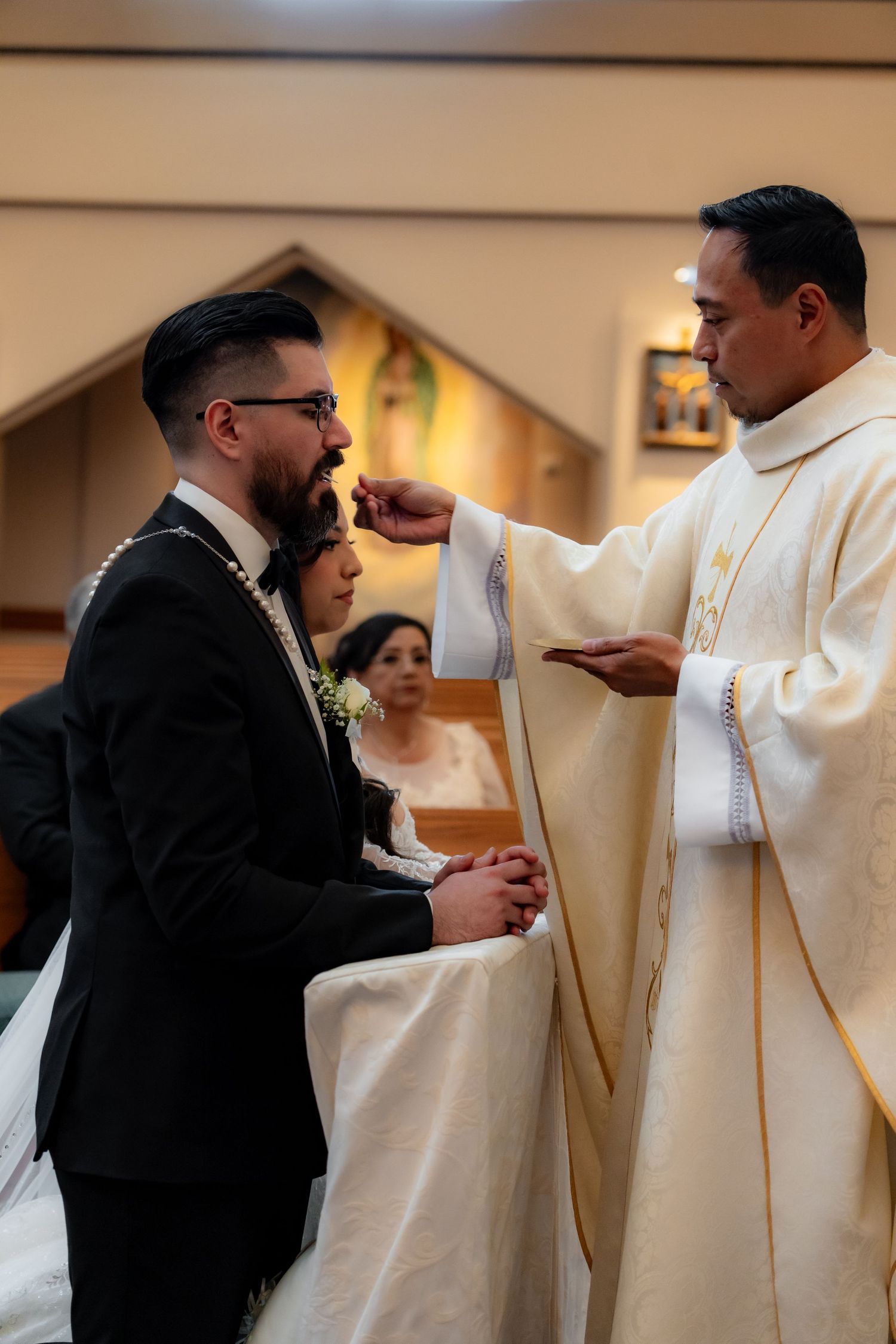 Religious blessing being given during Catholic wedding ceremony.