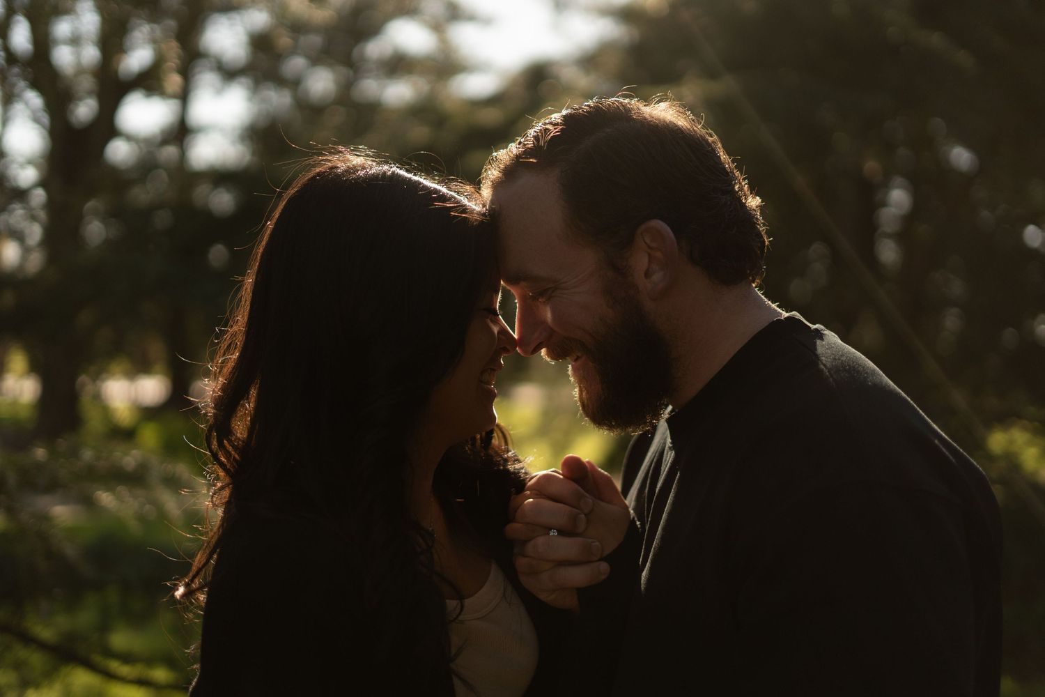 Intimate couple sharing a tender moment in the warm afternoon sunlight.