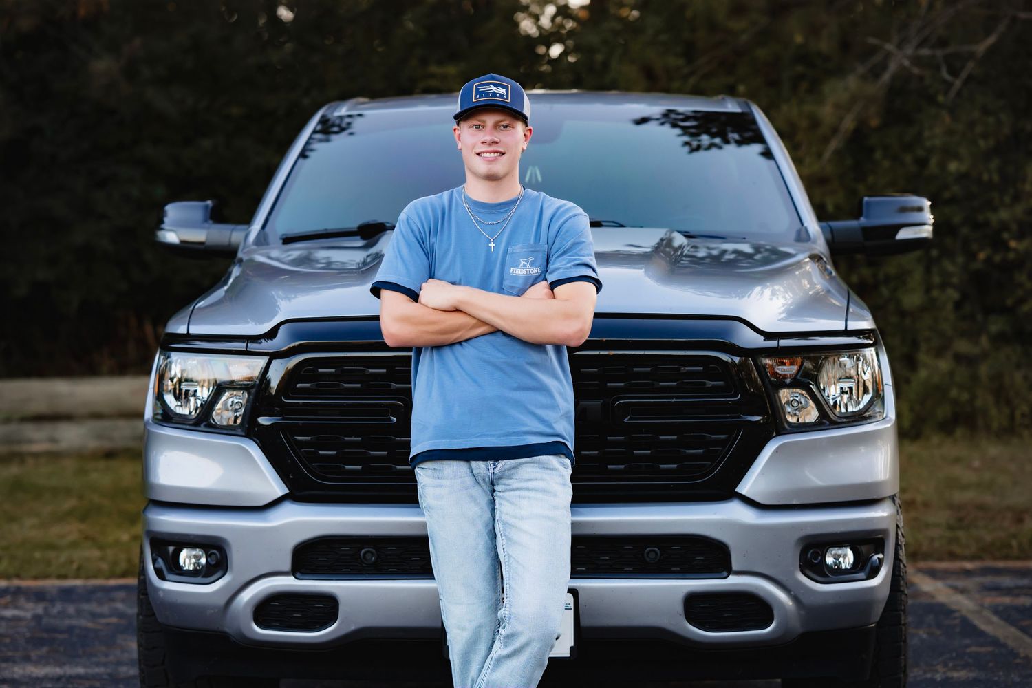A silver Ram pickup truck parked in an outdoor setting with trees in the background.