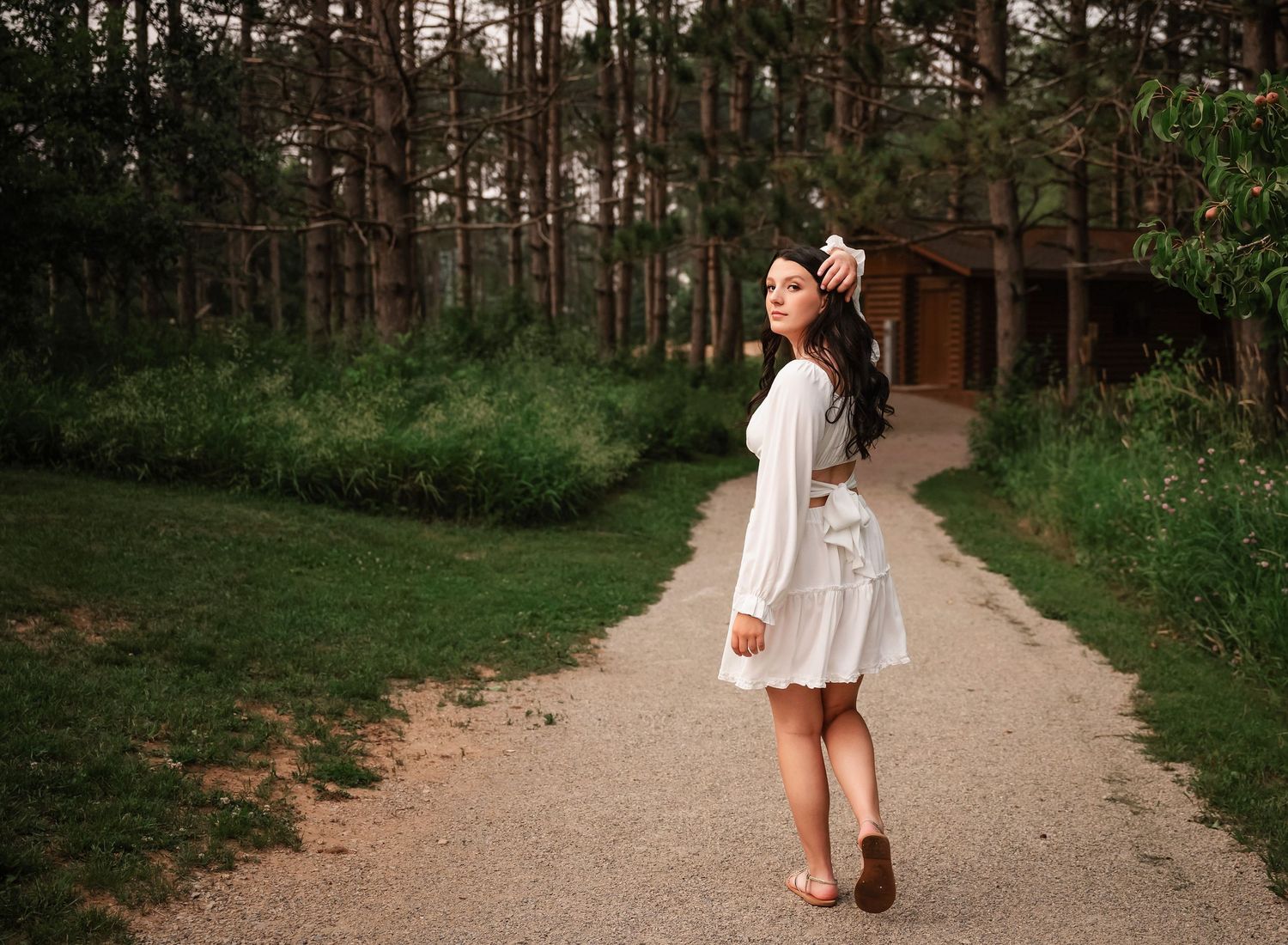 Natural outdoor photo session on a winding dirt path through a pine forest.