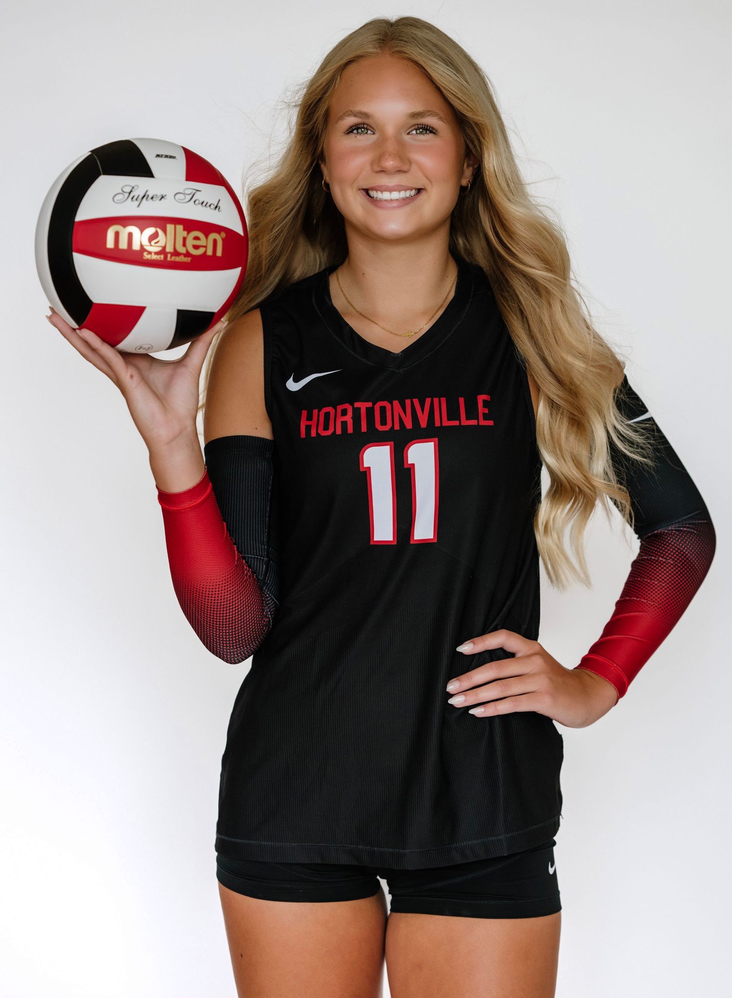 Hortonville volleyball player #11 posing with Molten ball in black and red uniform.